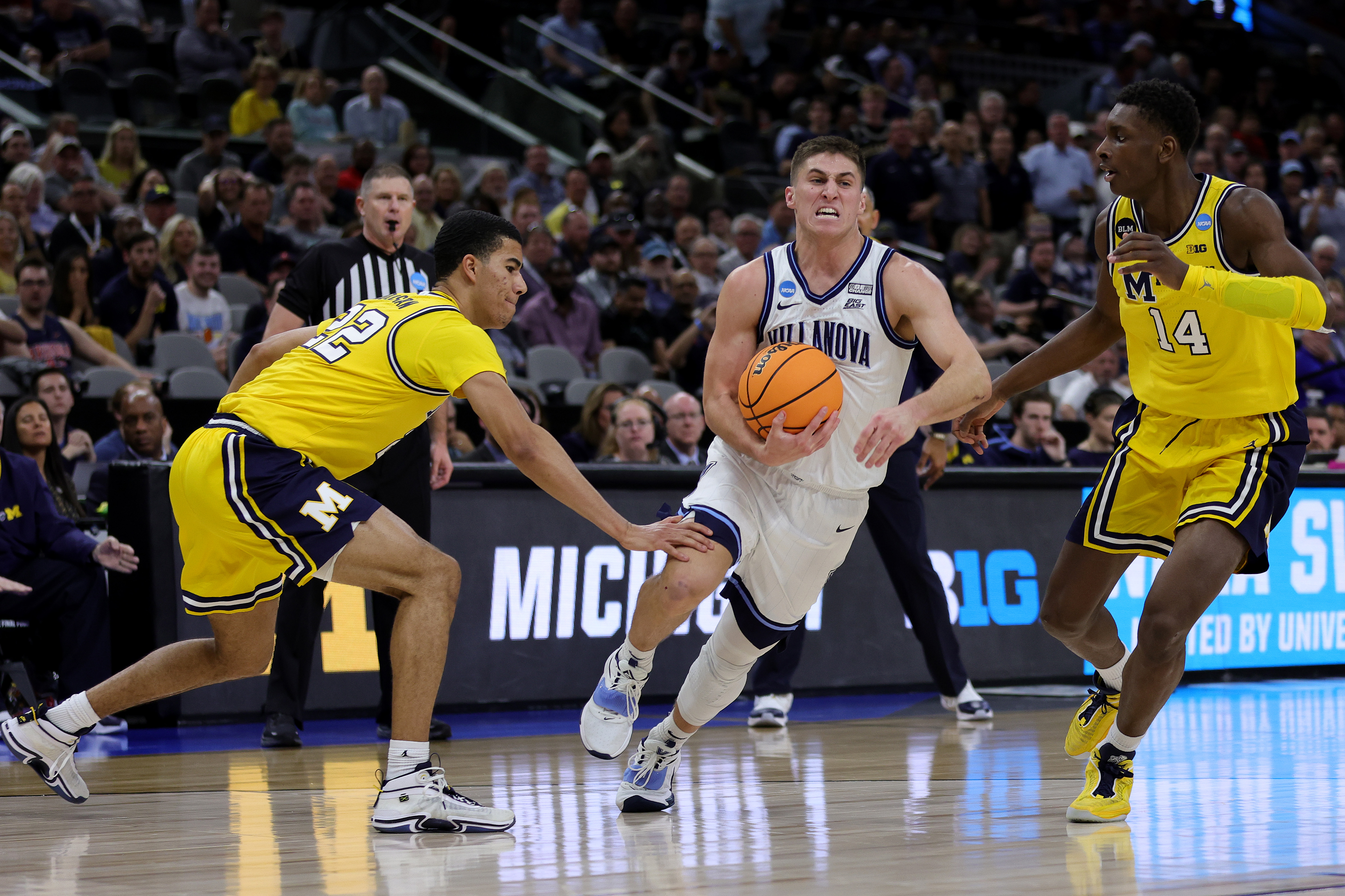 SAN ANTONIO, TEXAS - MARCH 24: Collin Gillespie #2 of the Villanova Wildcats drives between Caleb Houstan #22 and Moussa Diabate #14 of the Michigan Wolverines during the first half of the NCAA Men's Basketball Tournament Sweet 16 Round at AT&T Center on March 24, 2022 in San Antonio, Texas. (Photo by Carmen Mandato/Getty Images)