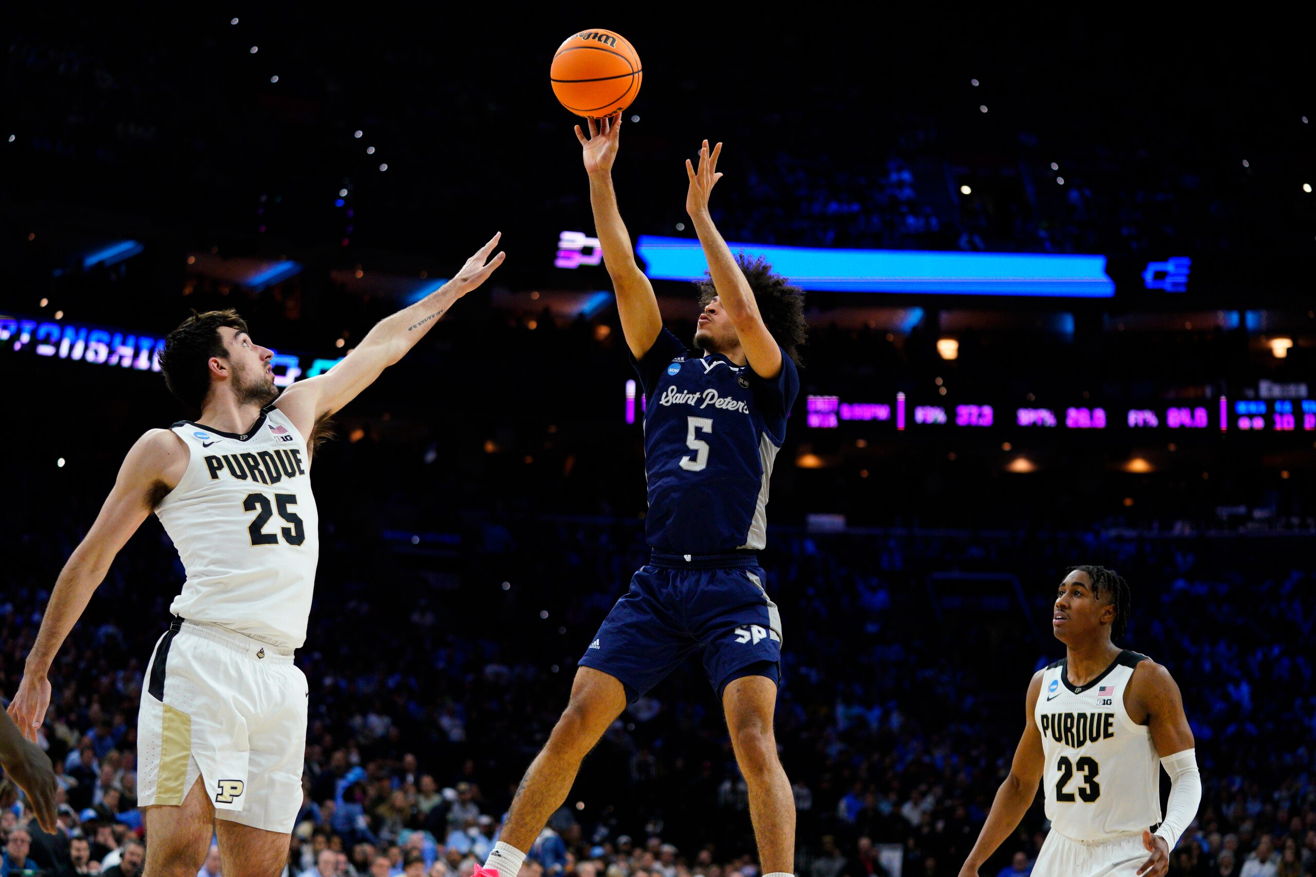 Saint Peter's Daryl Banks III, center, goes up for a shot against Purdue's Ethan Morton, left, Jaden Ivey during the second half of a college basketball game in the Sweet 16 round of the NCAA tournament, Friday, March 25, 2022, in Philadelphia. (AP Photo/Chris Szagola)