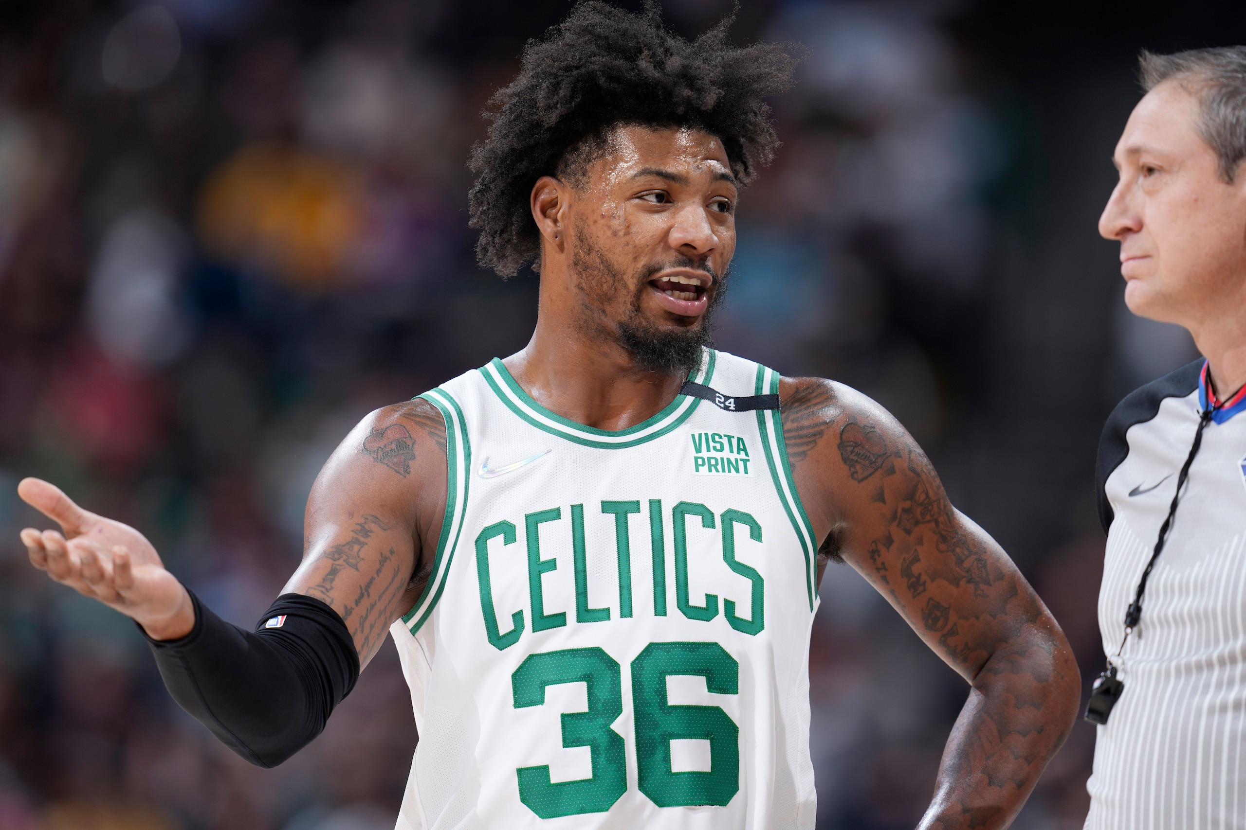 Boston Celtics guard Marcus Smart, left, talks with referee J.T. Orr in the first half of an NBA basketball game against the Denver Nuggets, Sunday, March 20, 2022, in Denver. (AP Photo/David Zalubowski)