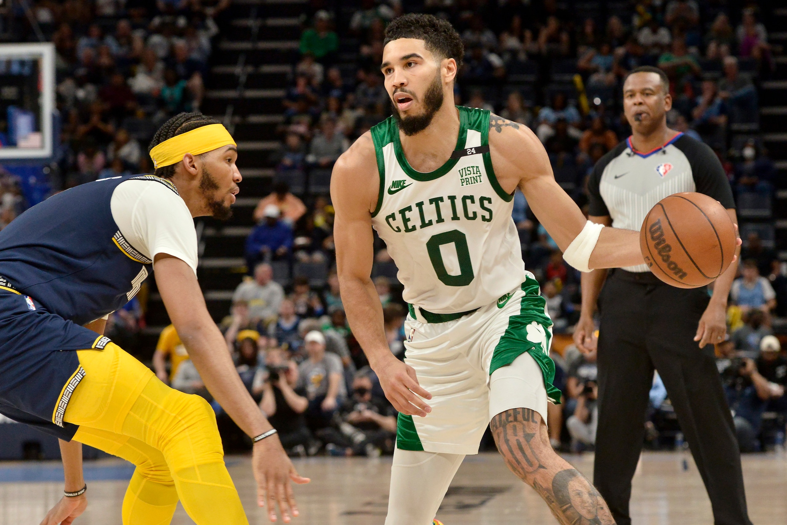 Boston Celtics forward Jayson Tatum (0) handles the ball against Memphis Grizzlies guard Ziaire Williams in the second half of an NBA basketball game Sunday, April 10, 2022, in Memphis, Tenn. (AP Photo/Brandon Dill)