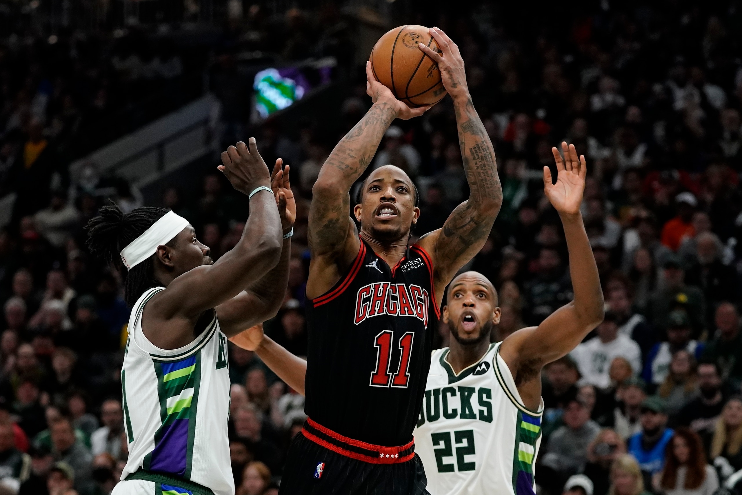 Chicago Bulls' DeMar DeRozan shoots past Milwaukee Bucks' Jrue Holiday during the second half of Game 1 of their first round NBA playoff basketball game Sunday, April 17, 2022, in Milwaukee. The Bucks won 93-86 to take a 1-0 lead in the series. (AP Photo/Morry Gash)
