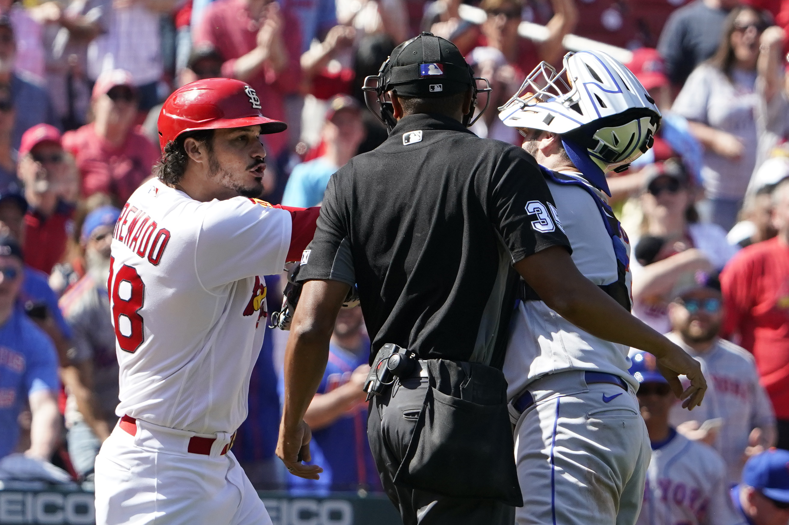 St. Louis Cardinals' Nolan Arenado (28) scuffles with New York Mets catcher Tomas Nido as home plate umpire Jeremie Rehak, center, watches during the eighth inning of a baseball game Wednesday, April 27, 2022, in St. Louis. Arenado was ejected from the game. (AP Photo/Jeff Roberson)