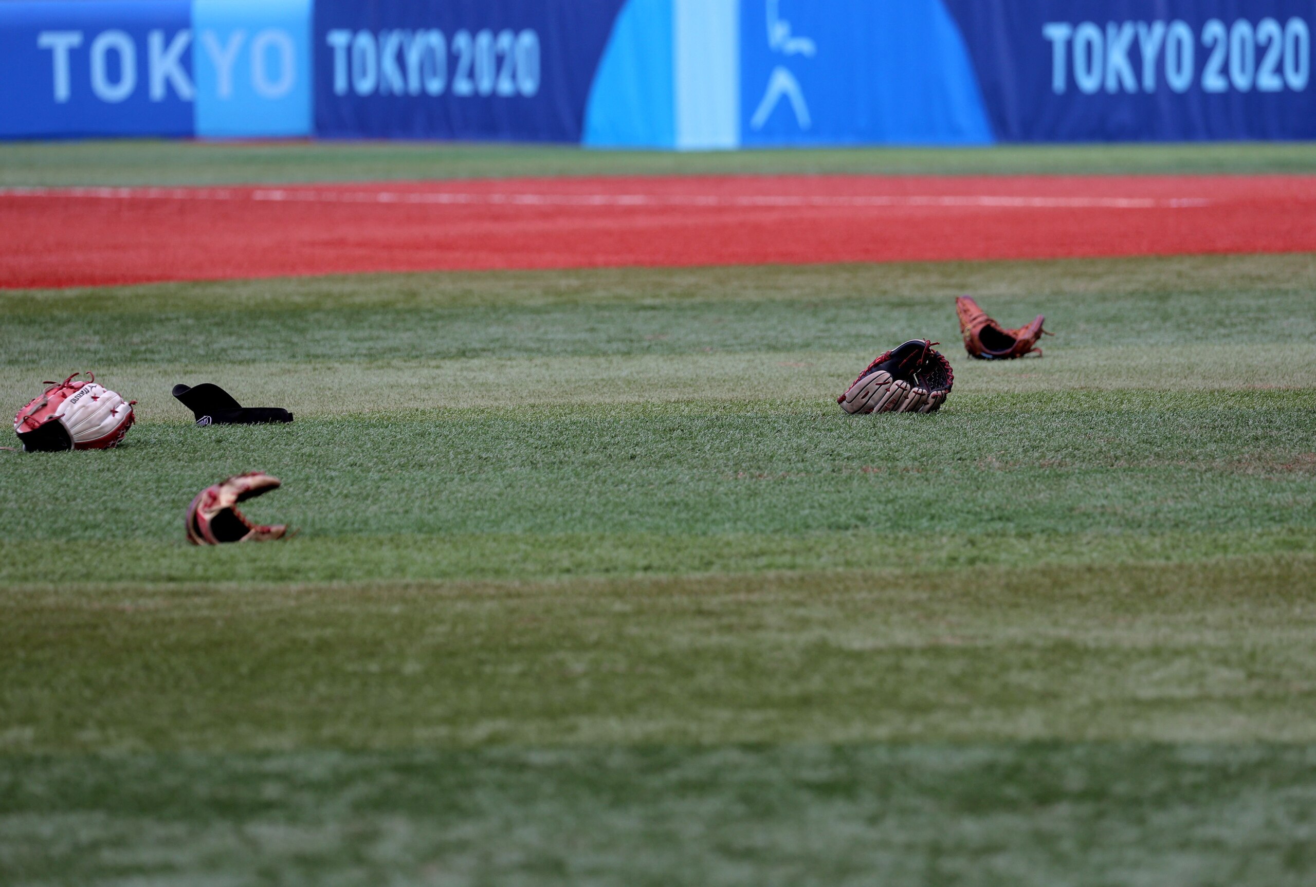 A cap and gloves of Canada's player lie on a ground after their victory during the Tokyo 2020 Olympic Games softball bronze medal game between Mexico and Canada at the Yokohama Baseball Stadium in Yokohama, Japan, on July 27, 2021. (Photo by KAZUHIRO FUJIHARA / AFP) (Photo by KAZUHIRO FUJIHARA/AFP via Getty Images)