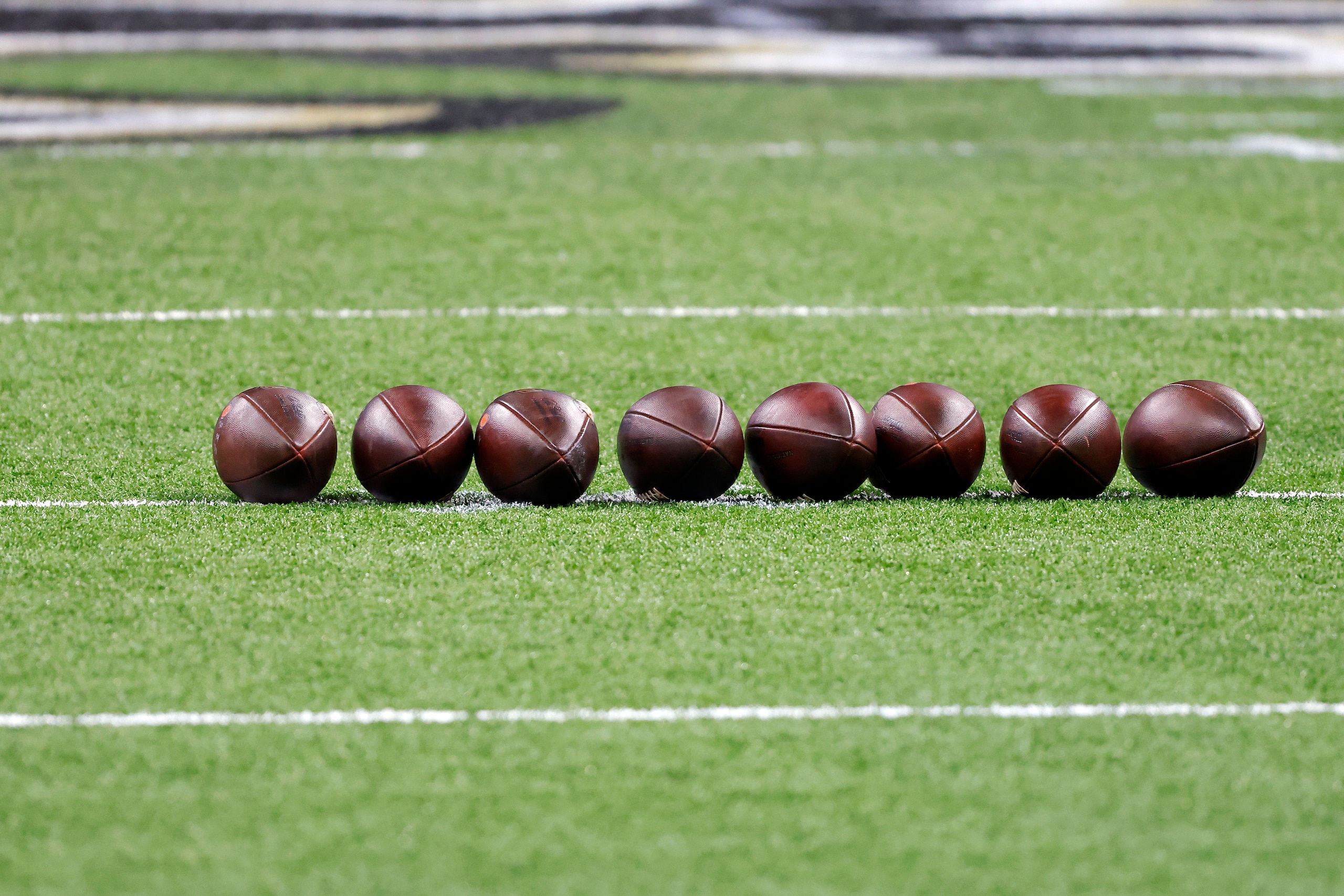 Footballs are seen on the field before an NFL wild-card playoff football game between the New Orleans Saints and the Chicago Bears, Sunday, Jan. 10, 2021, in New Orleans. The Saints defeated the Bears 21-9. (AP Photo/Tyler Kaufman)