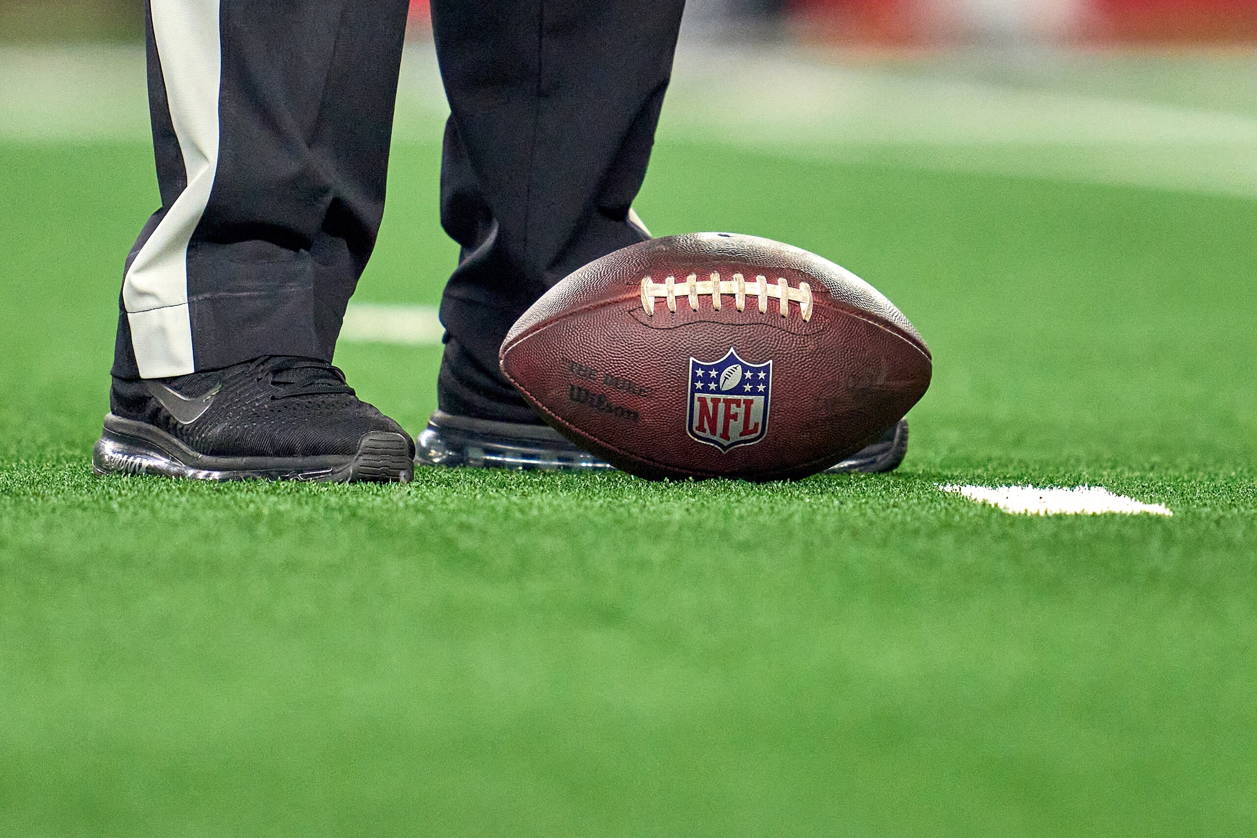 ARLINGTON, TX - JANUARY 16: A detail view of the NFL logo crest is seen on a Wilson game ball resting on the field during the NFC Wild Card game between the San Francisco 49ers and the Dallas Cowboys on January 16, 2022 at AT&T Stadium in Arlington, TX. (Photo by Robin Alam/Icon Sportswire via Getty Images)