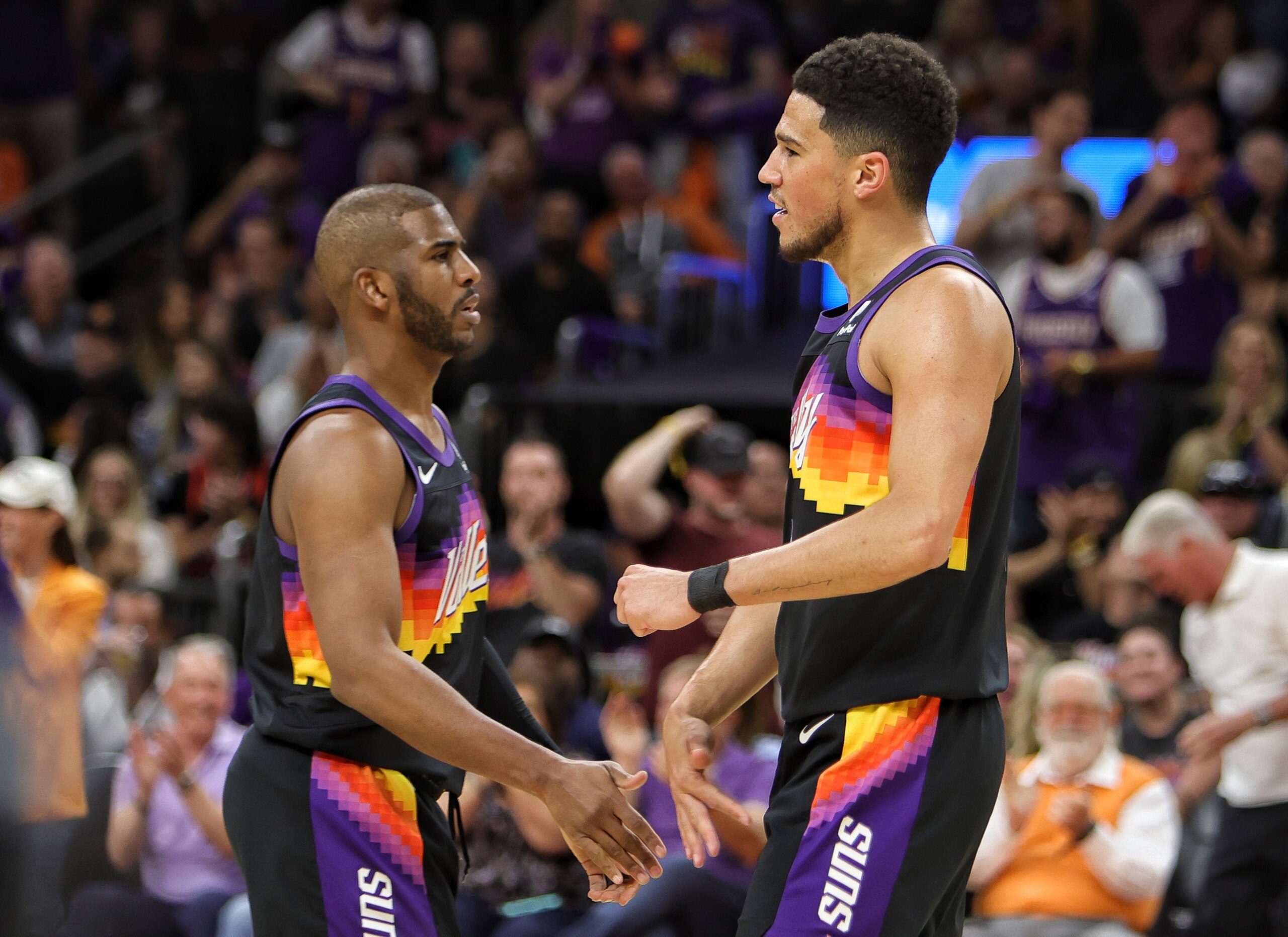 PHOENIX, AZ - MAY 2:  Chris Paul #3 and Devin Booker #1 of the Phoenix Suns look on during the game against the Dallas Mavericks during Game 1 of the 2022 NBA Playoffs Western Conference Semifinals on May 2, 2022 at Footprint Center in Phoenix, Arizona. NOTE TO USER: User expressly acknowledges and agrees that, by downloading and or using this photograph, user is consenting to the terms and conditions of the Getty Images License Agreement. Mandatory Copyright Notice: Copyright 2022 NBAE (Photo by Jim Poorten/NBAE via Getty Images)