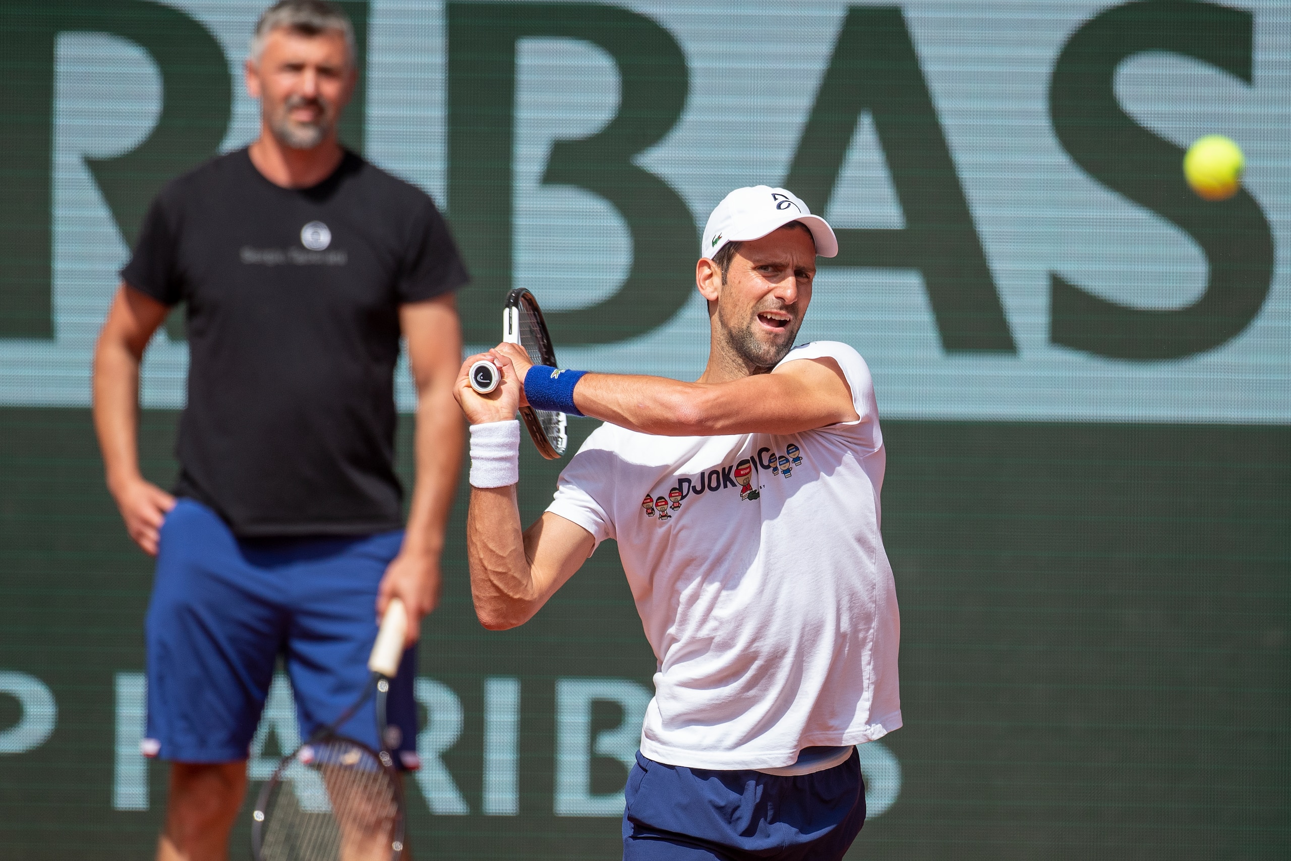 PARIS, FRANCE May 19. Novak Djokovic of Serbia watched by coach Goran Ivanisevic during practice on Court Philippe Chatrier in preparation for the 2022 French Open Tennis Tournament at Roland Garros on May 19th 2022 in Paris, France. (Photo by Tim Clayton/Corbis via Getty Images)