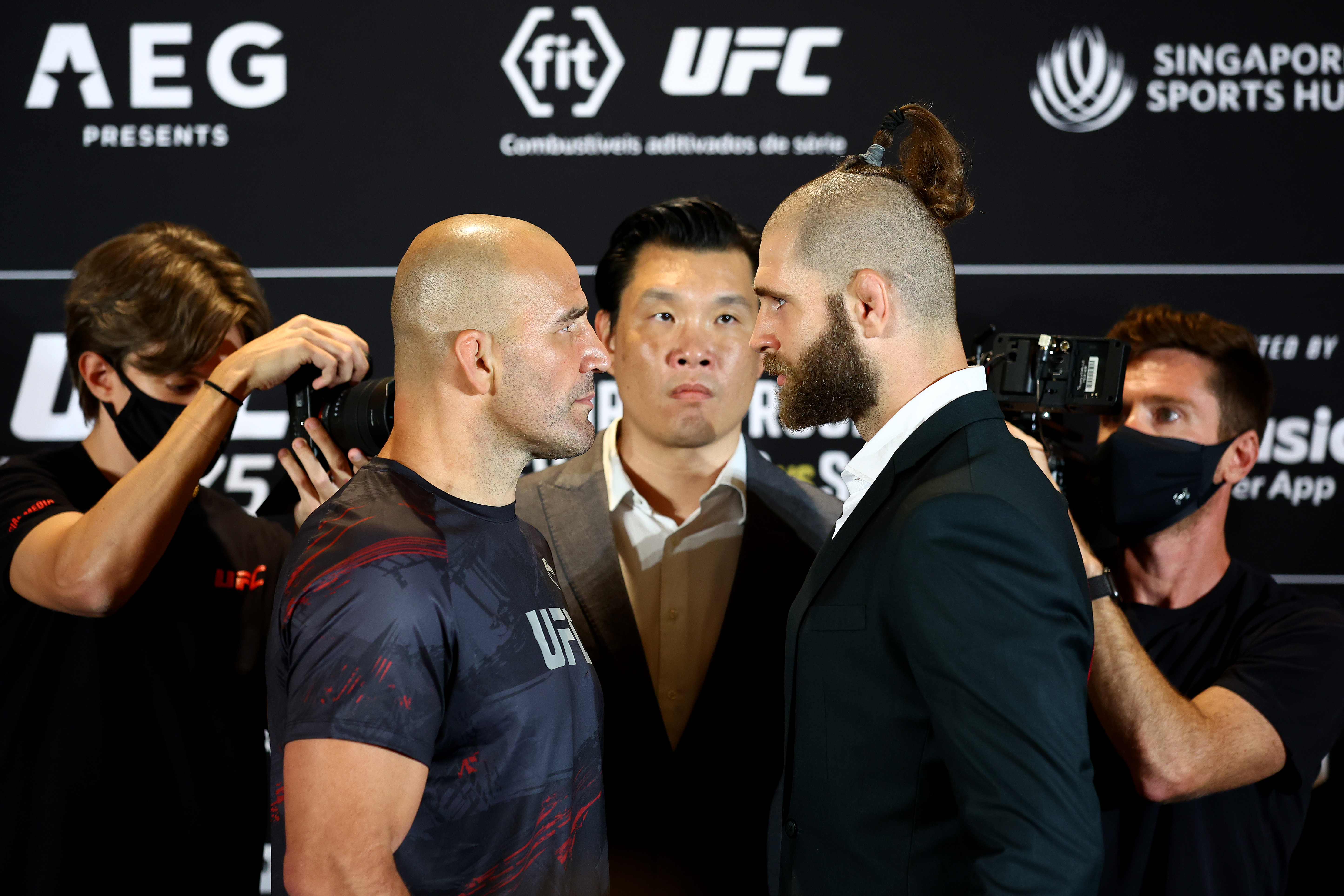 SINGAPORE, SINGAPORE - JUNE 08: UFC light heavyweight champion Glover Texeira (2L) of Brazil and Jiri Prochazka (2R) of the Czech Republic face off ahead of their title bout as UFC Senior Vice President Kevin Chang (C) looks on during UFC 275 Media Day at Mandarin Oriental on June 08, 2022 in Singapore. (Photo by Yong Teck Lim/Getty Images)