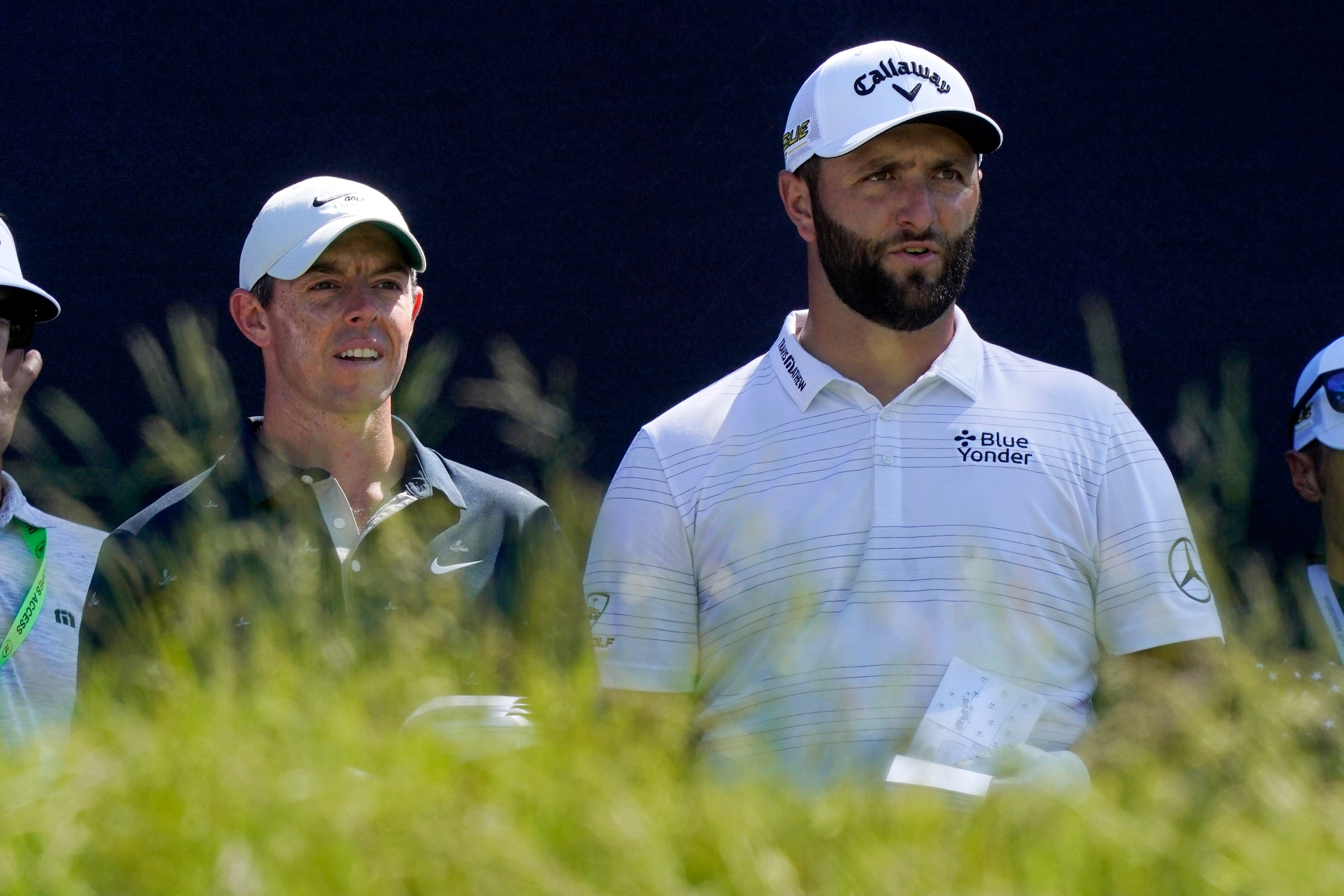 Rory McIlroy, left, of Northern Ireland, and Jon Rahm, of Spain, talk before teeing off at the fifth hole at The Country Club, Monday, June 13, 2022, in Brookline, Mass., during a practice round ahead of the U.S. Open golf tournament. (AP Photo/Robert F. Bukaty)