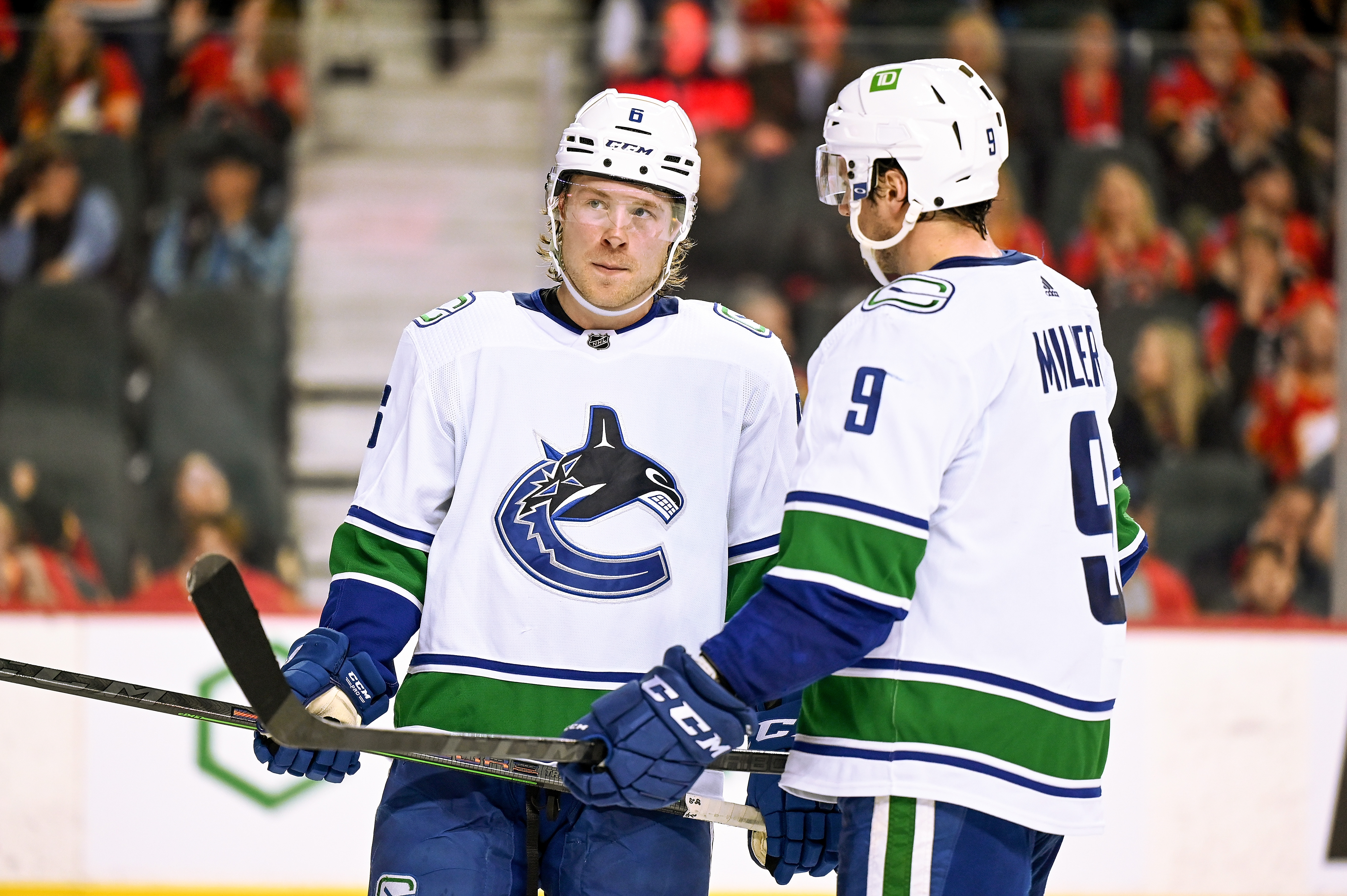 CALGARY, AB - APRIL 23: Vancouver Canucks Right Wing Brock Boeser (6) and Vancouver Canucks Center J.T. Miller (9) talk strategy during the third period of an NHL game where the Calgary Flames hosted the Vancouver Canucks on April 23, 2022, at the Scotiabank Saddledome in Calgary, AB. (Photo by Brett Holmes/Icon Sportswire via Getty Images)