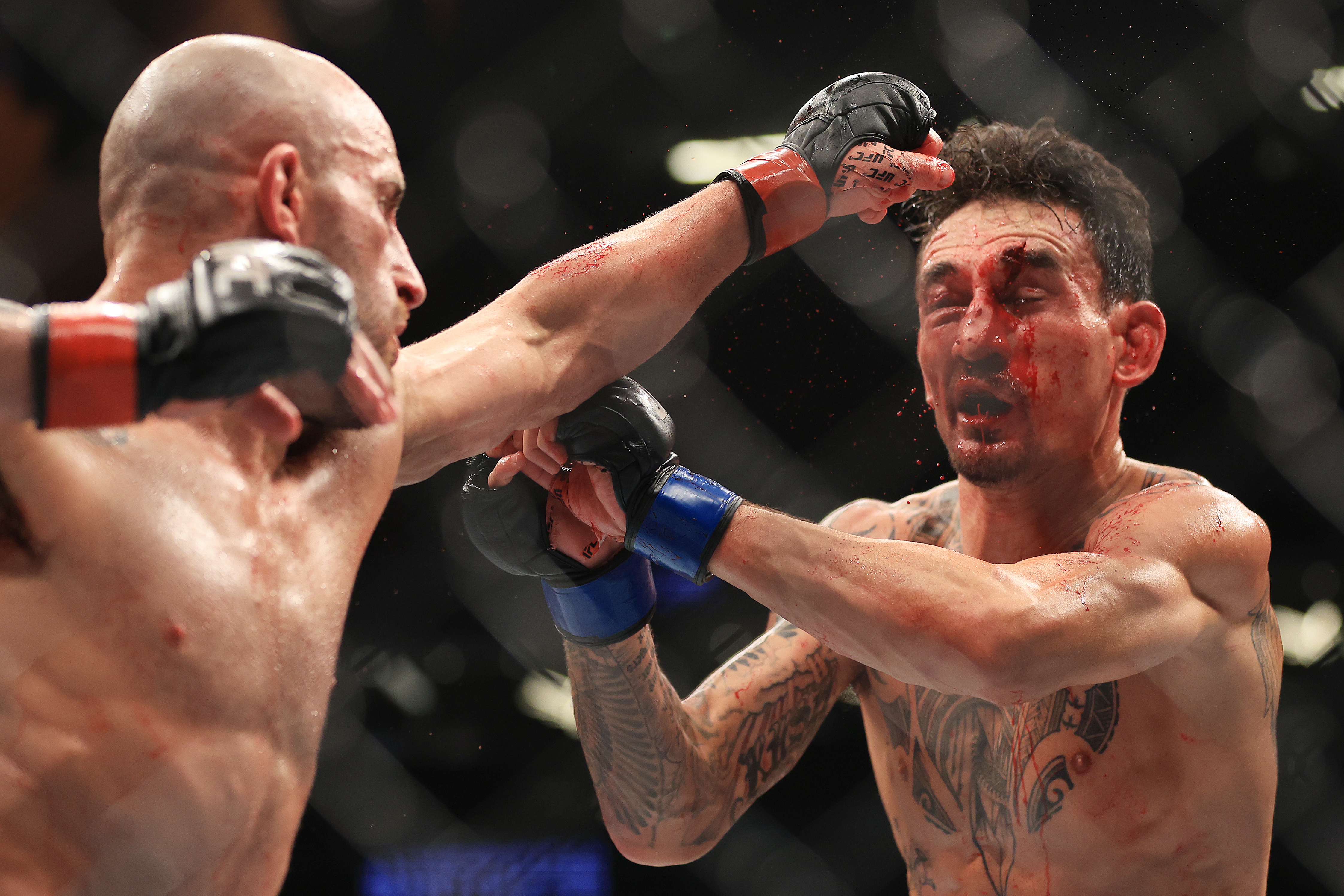 LAS VEGAS, NEVADA - JULY 02: Alexander Volkanovski (L) of Australia punches Max Holloway in their featherweight title bout during UFC 276 at T-Mobile Arena on July 02, 2022 in Las Vegas, Nevada. (Photo by Carmen Mandato/Getty Images)