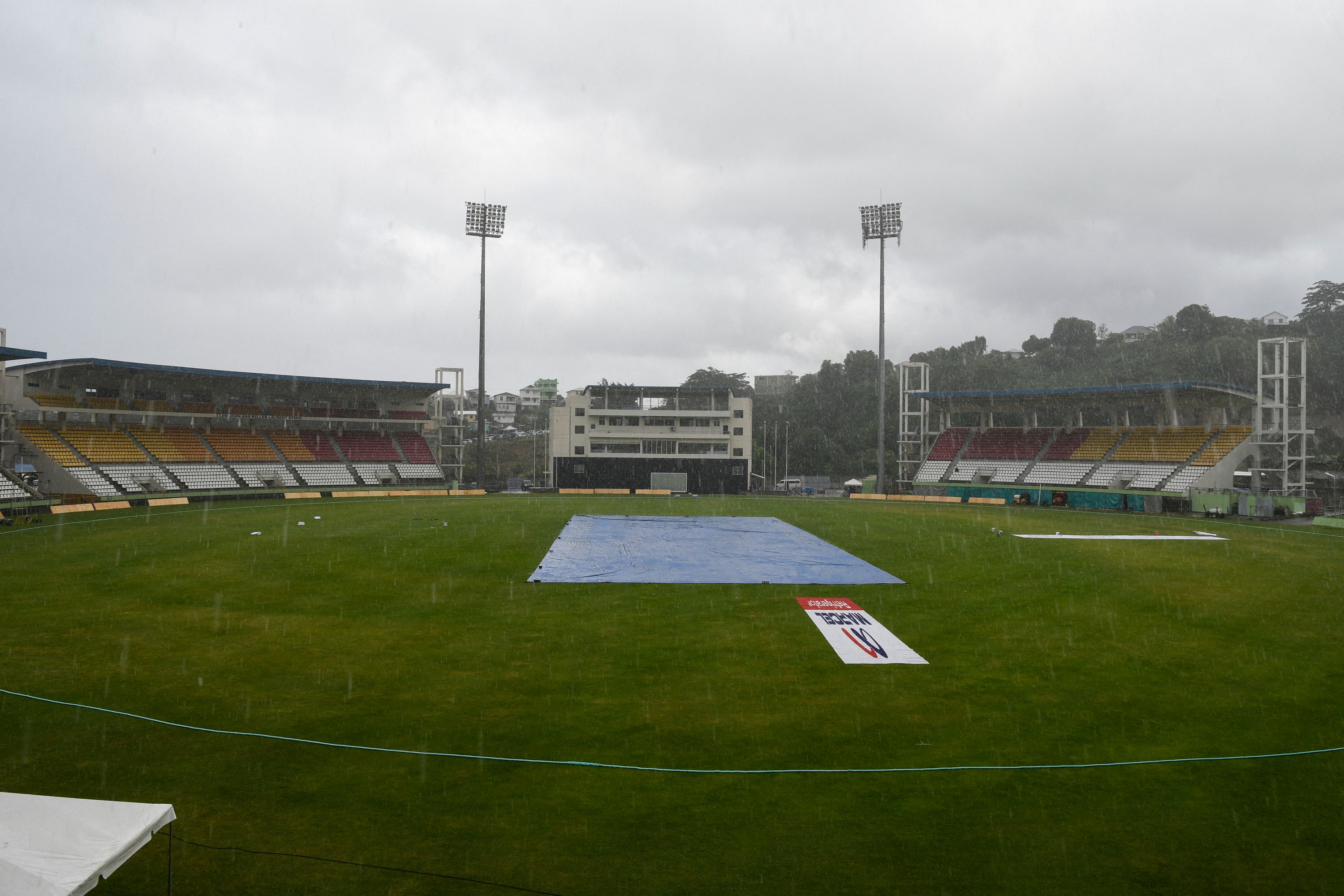 A tarp covers the pitch to protect it from rain during a cancelled training session one day ahead of the 1st T20I between West Indies and Bangladesh at Windsor Park, Roseau, Dominica, on July 01, 2022. (Photo by Randy Brooks / AFP) (Photo by RANDY BROOKS/AFP via Getty Images)