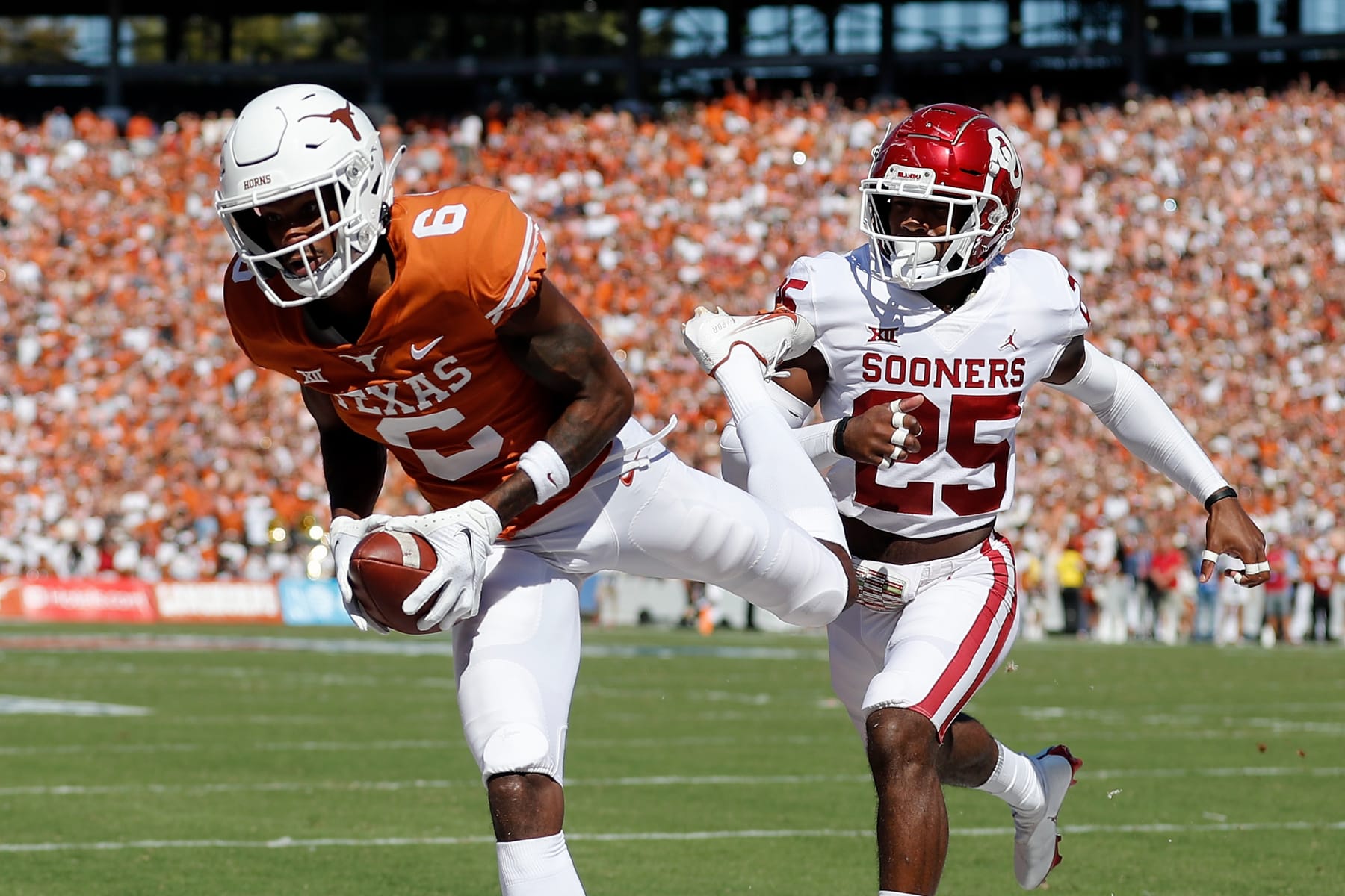 DALLAS, TEXAS - OCTOBER 09: Joshua Moore #6 of the Texas Longhorns catches a pass for a touchdown while defended by Justin Broiles #25 of the Oklahoma Sooners in the first quarter during the 2021 AT&T Red River Showdown at Cotton Bowl on October 09, 2021 in Dallas, Texas. (Photo by Tim Warner/Getty Images)