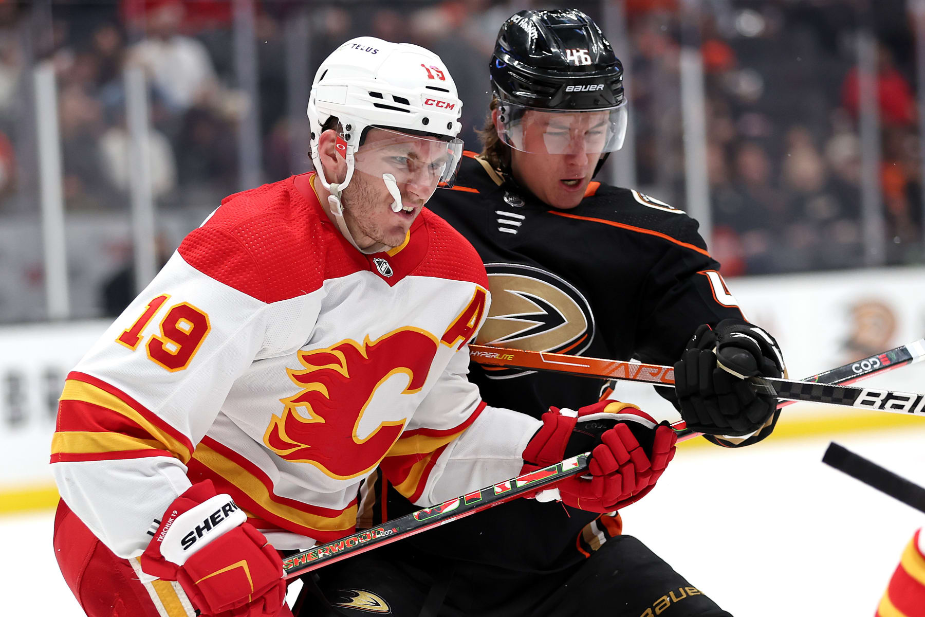 ANAHEIM, CALIFORNIA - APRIL 06: Matthew Tkachuk #19 of the Calgary Flames checks Trevor Zegras #46 of the Anaheim Ducks at the faceoff circle during the third period of a game at Honda Center on April 06, 2022 in Anaheim, California. (Photo by Sean M. Haffey/Getty Images)