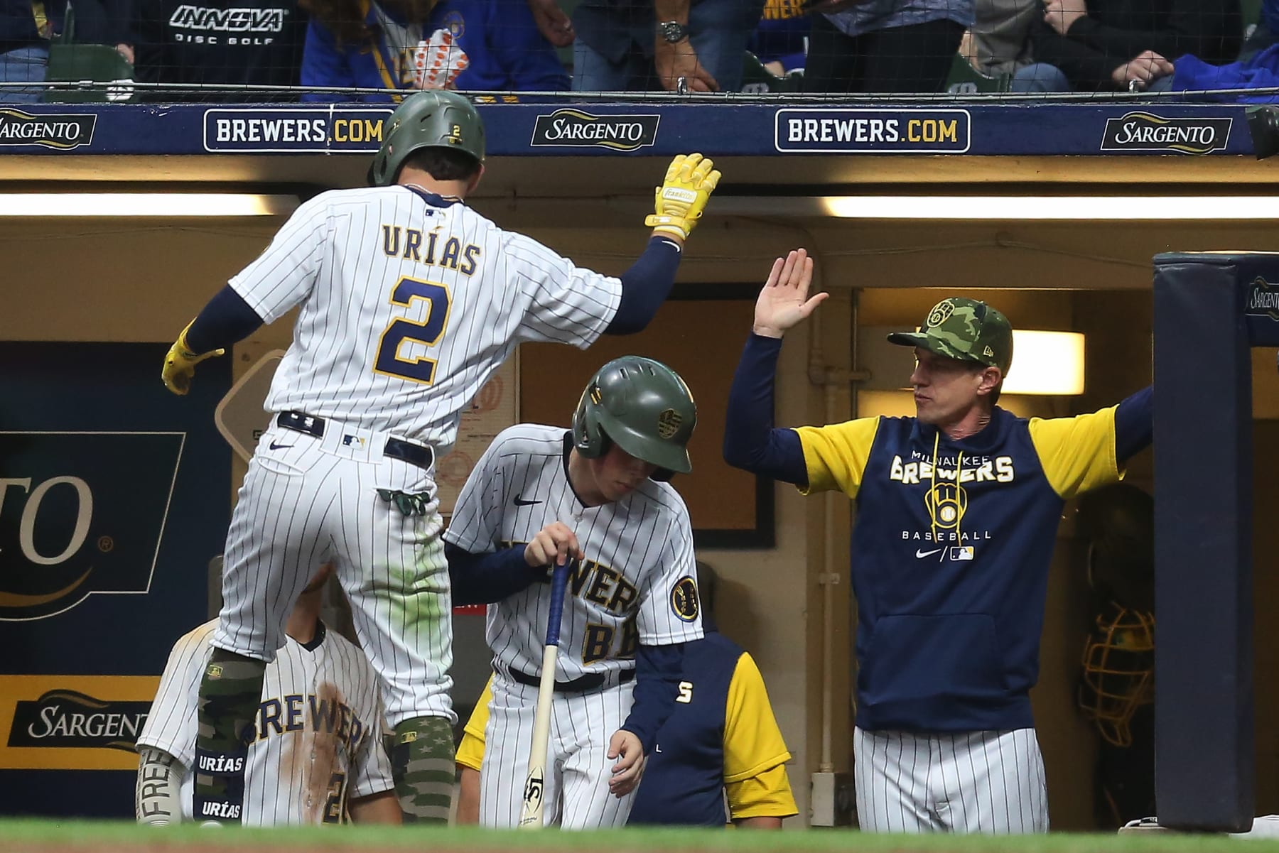 MILWAUKEE, WI - MAY 21: Milwaukee Brewers manager Craig Counsell (30) reaches out to high five Milwaukee Brewers shortstop Luis Urias (2) during a game between the Milwaukee Brewers and the Washington Nationals at American Family Field on May 21, 2022 in Milwaukee, WI.(Photo by Larry Radloff/Icon Sportswire via Getty Images)