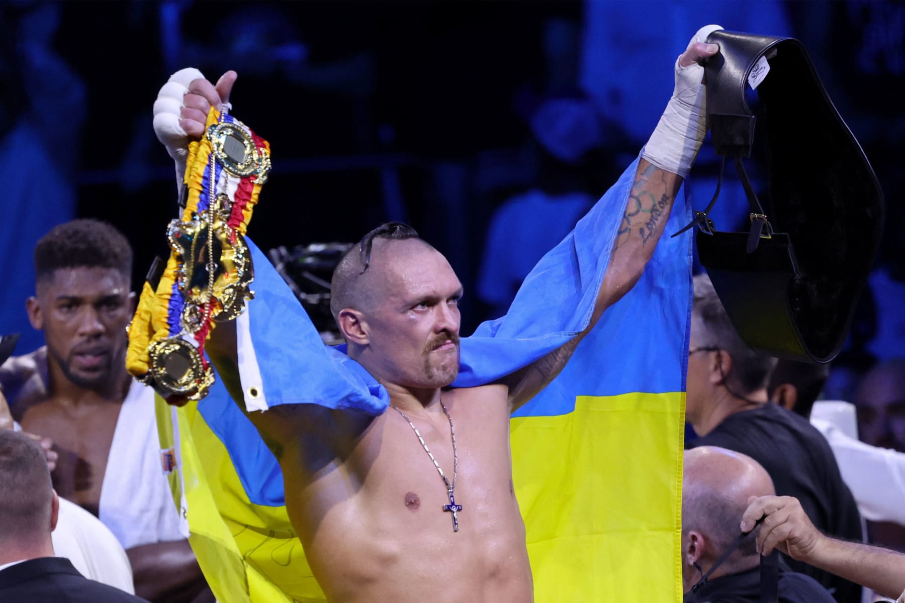 Ukraine's Oleksandr Usyk (C) celebrates after winning the heavyweight boxing rematch for the WBA, WBO, IBO and IBF titles against Britain's Anthony Joshua (L), at the King Abdullah Sports City Arena in the Saudi Red Sea city of Jeddah, on August 20, 2022. - Usyk won his rematch against Anthony Joshua by split decision to retain his world heavyweight titles in just his fourth fight in the division in Saudi Arabia late tonight. (Photo by Giuseppe CACACE / AFP) (Photo by GIUSEPPE CACACE/AFP via Getty Images)