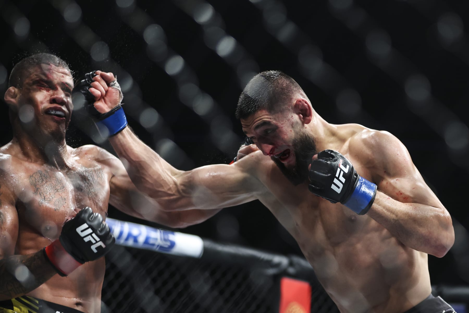 JACKSONVILLE, FLORIDA - APRIL 09: Khamzat Chimaev of Russia punches Gilbert Burns of Brazil in their welterweight fight during the UFC 273 event at VyStar Veterans Memorial Arena on April 09, 2022 in Jacksonville, Florida. (Photo by James Gilbert/Getty Images)