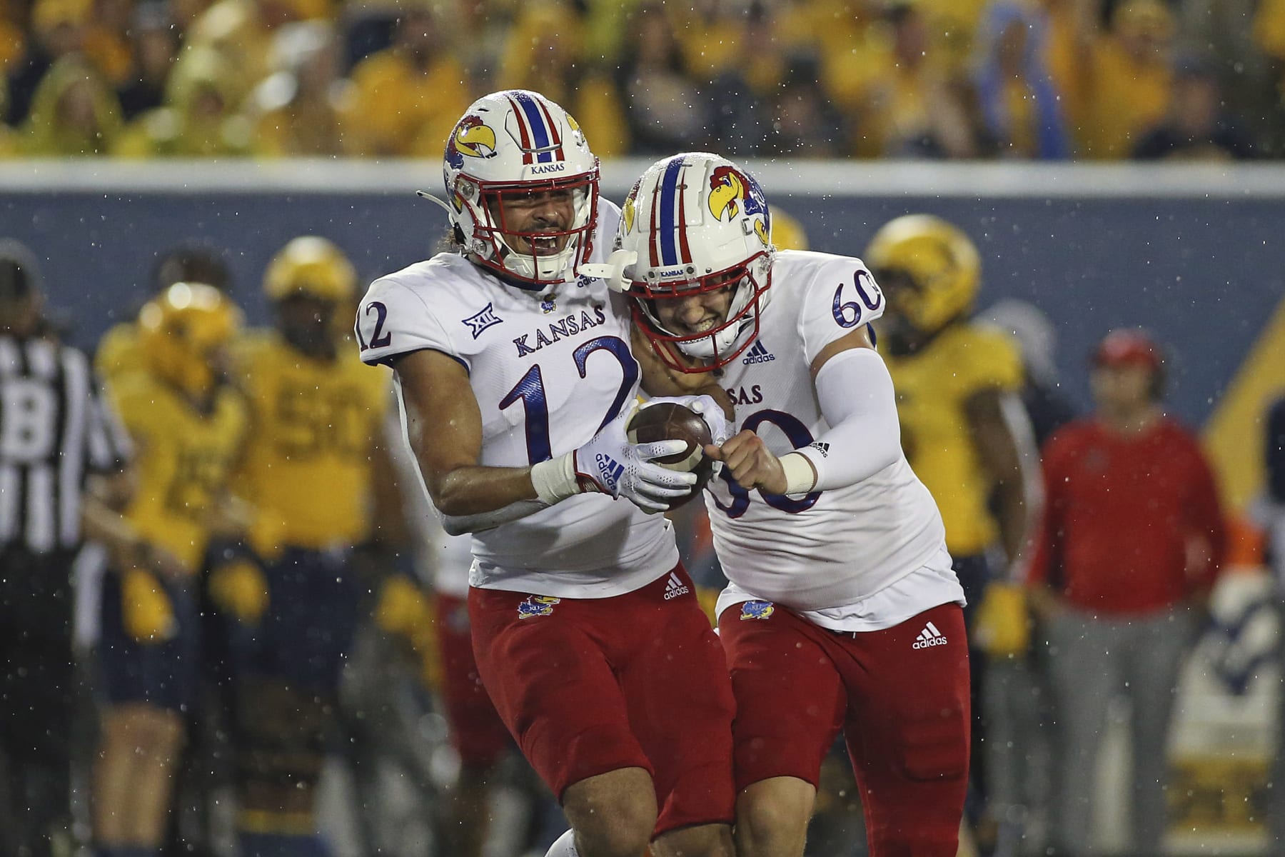 Kansas running back Torry Locklin (12) and long snapper Luke Hosford (60) celebrate after Locklin recovered a fumble during the second half of an NCAA college football game against West Virginia in Morgantown, W.Va., Saturday, Sept. 10, 2022. (AP Photo/Kathleen Batten)