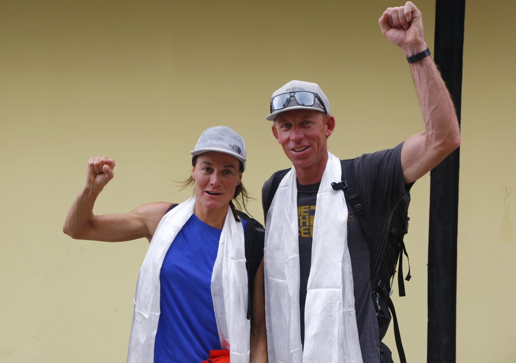 FILE- Hilaree Nelson of Telluride, Colorado, left and James Morrison of Tahoe, California, raise their fists as the pair arrived in Kathmandu, Nepal, Oct. 4, 2018. Rescuers in a helicopter were searching on the world's eighth-highest mountain Tuesday for Nelson, the famed U.S. ski mountaineer a day after she fell off the mountain near the peak. Nelson, 49, was skiing down from the 8,163-meter (26,775-foot) summit with her partner Jim Morrison when she fell off the mountain, according to Jiban Ghimire of the Kathmandu-based Shangri-La Nepal Trek that organized and outfitted the expedition.(AP Photo/Niranjan Shrestha, File)