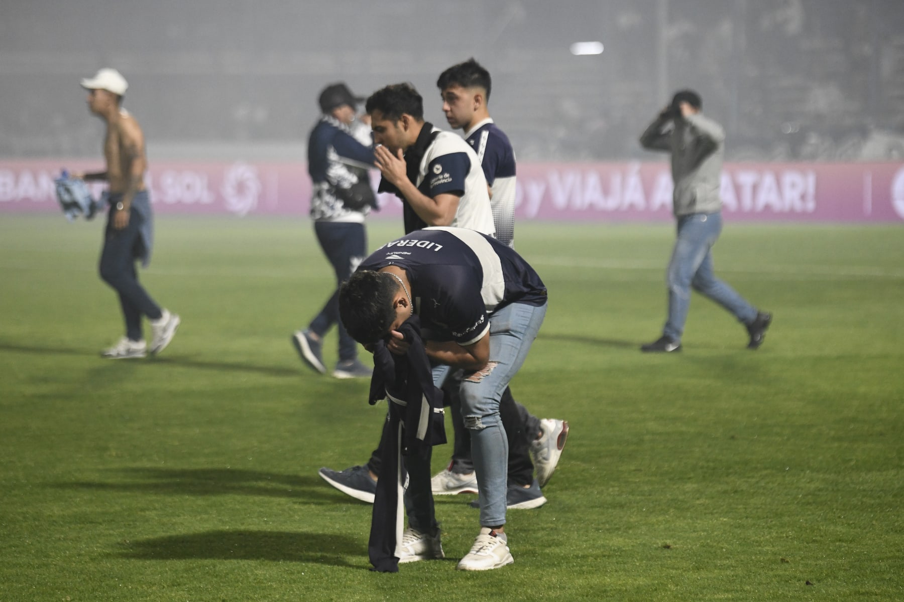 LA PLATA, ARGENTINA - OCTOBER 06: Fans of Gimnasia cover their faces as they are affected by tear gas after a match between Gimnasia y Esgrima La Plata and Boca Juniors was cancelled as part of Liga Profesional 2022 at Juan Carmelo Zerillo Stadium on October 6, 2022 in La Plata, Argentina. The match was stopped at nine minutes of play and later cancelled amid serious incidents outside the stadium with fans and police officers who used tear gas and rubber bullets to disperse the crowd. It was reported a fan of Gimnasia died and many were injured.(Photo by Gustavo Garello/Jam Media/Getty Images)