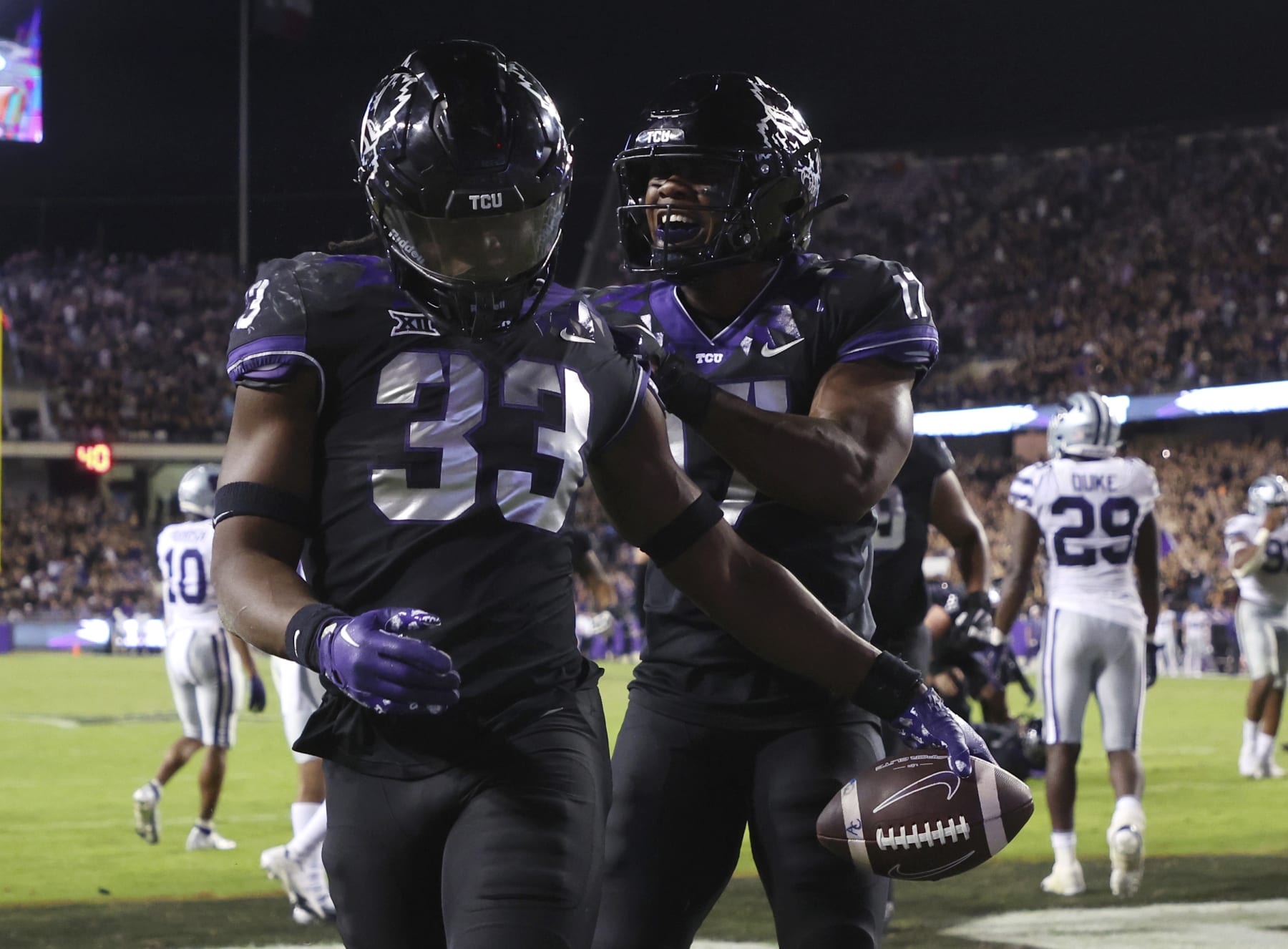 TCU running back Kendre Miller (33) and teammate Trent Battle (17) celebrate a touchdown against Kansas State during the second half of an NCAA college football game Saturday, Oct. 22, 2022, in Fort Worth, Texas. (AP Photo/Richard W. Rodriguez)