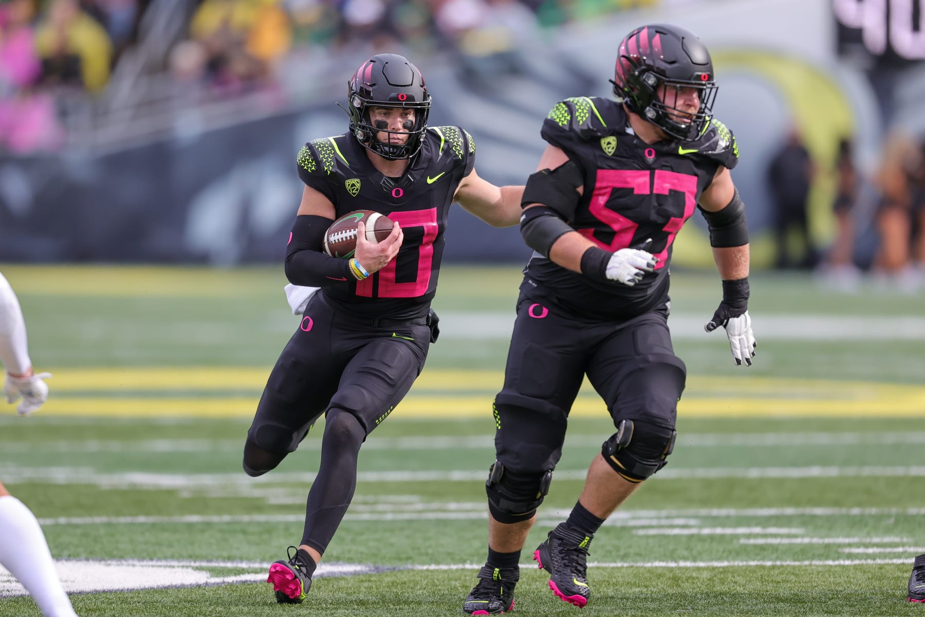 EUGENE, OR - OCTOBER 22: Oregon Ducks quarterback Bo Nix (10) runs behind the blocking of Oregon Ducks offensive lineman Ryan Walk (53)j against the UCLA Bruins defense during the second half of a college football game between the Oregon Ducks and UCLA Bruins on October 22, 2022 at Autzen Stadium in Eugene, OR. (Photo by Steve Conner/Icon Sportswire via Getty Images)