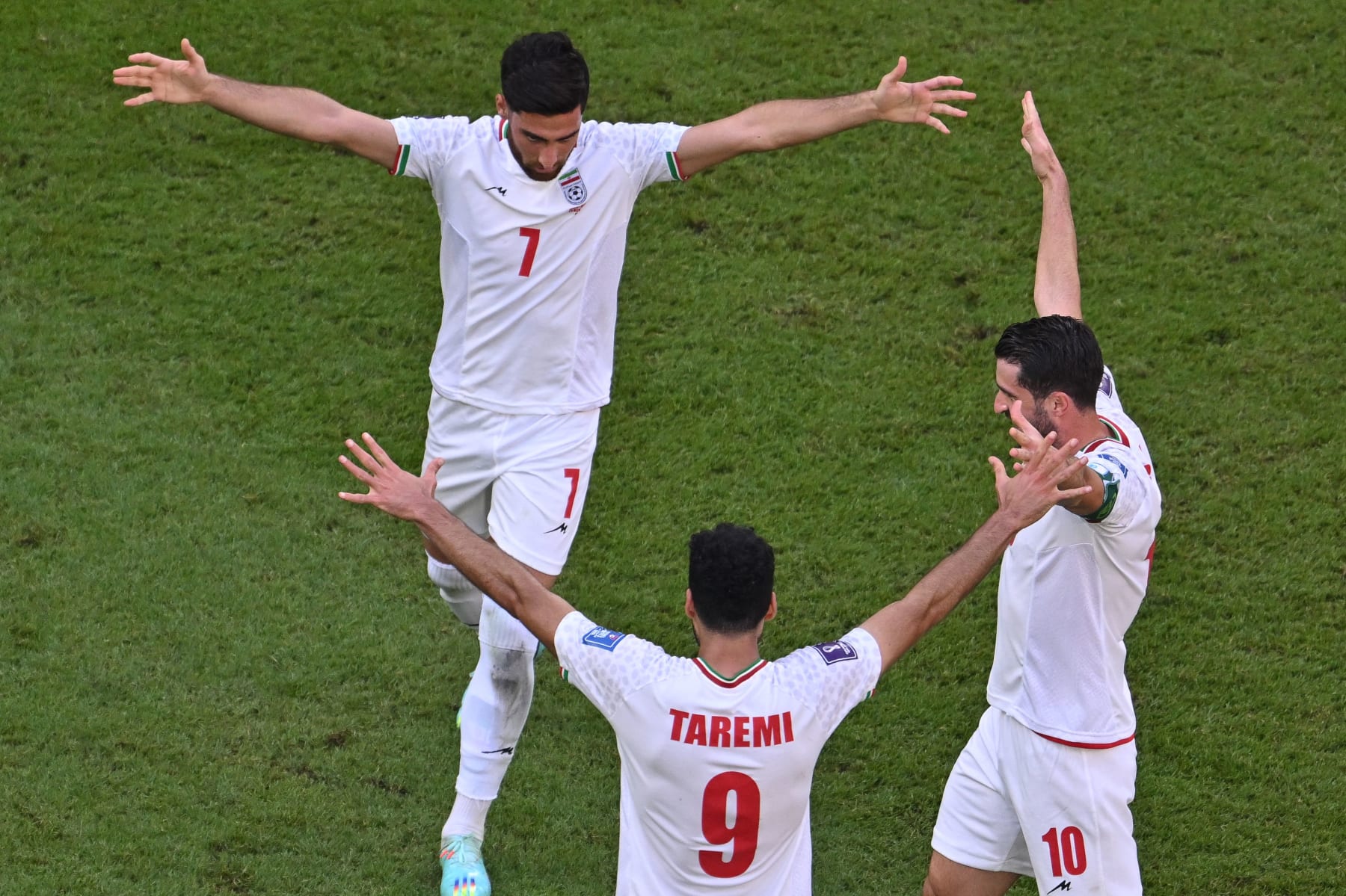 Iran's midfielder #07 Alireza Jahanbakhsh, Iran's forward #09 Mehdi Taremi, and Iran's forward #10 Karim Ansarifard celebrate the team's victory during the Qatar 2022 World Cup Group B football match between Wales and Iran at the Ahmad Bin Ali Stadium in Al-Rayyan, west of Doha on November 25, 2022. (Photo by Antonin THUILLIER / AFP) (Photo by ANTONIN THUILLIER/AFP via Getty Images)