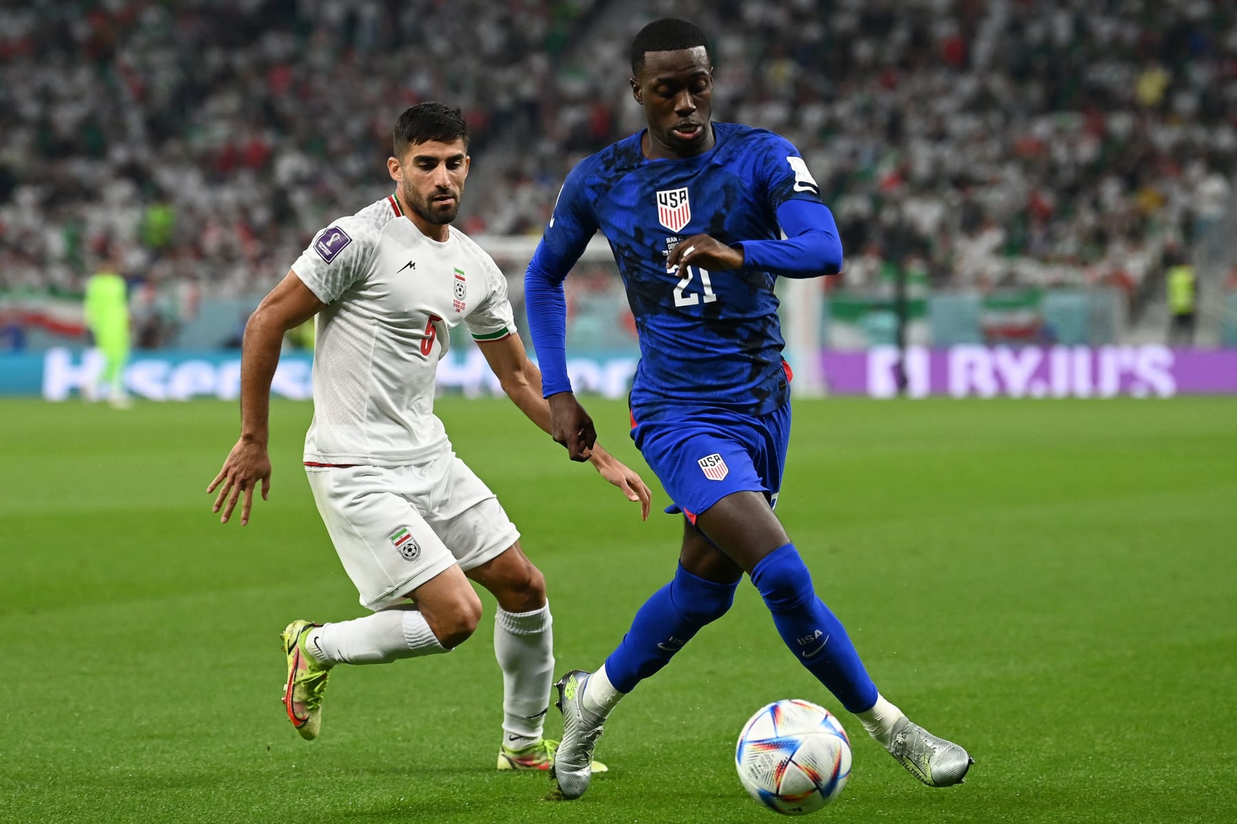 USA's forward #21 Timothy Weah fights for the ball with Iran's defender #05 Milad Mohammadi during the Qatar 2022 World Cup Group B football match between Iran and USA at the Al-Thumama Stadium in Doha on November 29, 2022. (Photo by Glyn KIRK / AFP) (Photo by GLYN KIRK/AFP via Getty Images)