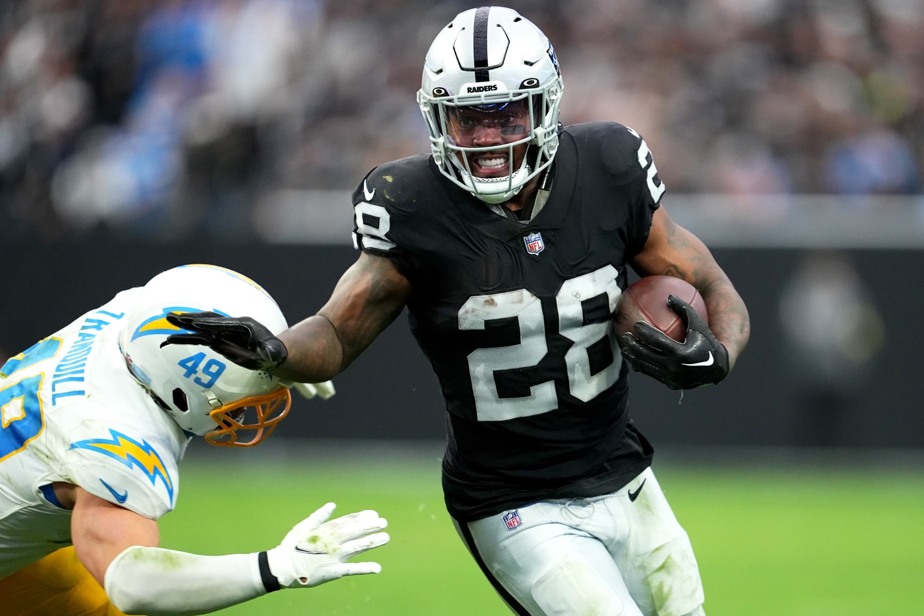 LAS VEGAS, NEVADA - DECEMBER 04: Josh Jacobs #28 of the Las Vegas Raiders runs with the ball in the second quarter of a game against the Los Angeles Chargers at Allegiant Stadium on December 04, 2022 in Las Vegas, Nevada. (Photo by Chris Unger/Getty Images)