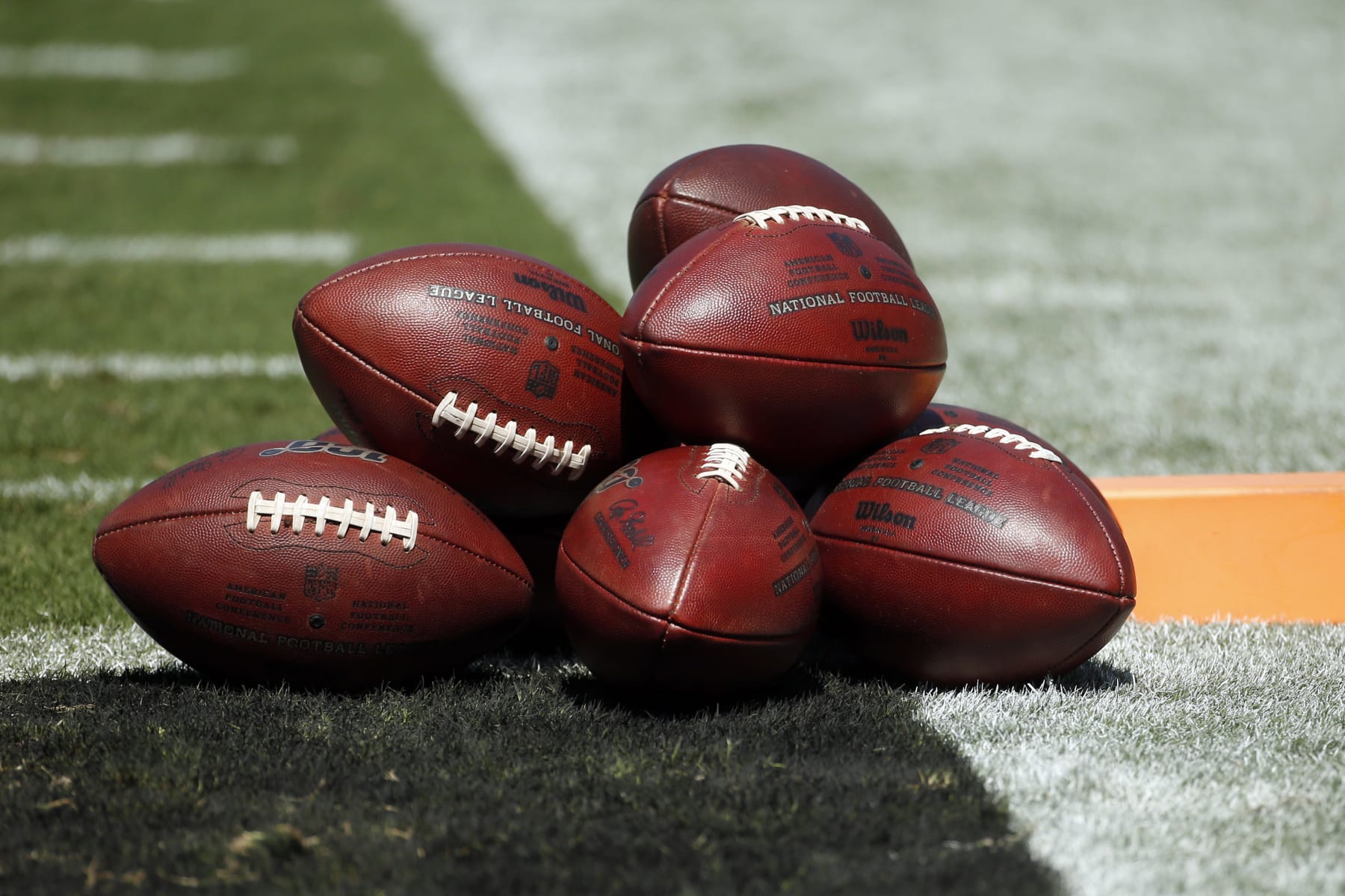 Footballs are piled on the field prior to an NFL football game between the Carlina Panthers and the Los Angeles Rams in Charlotte, N.C., Sunday, Sept. 8, 2019. (AP Photo/Brian Blanco)