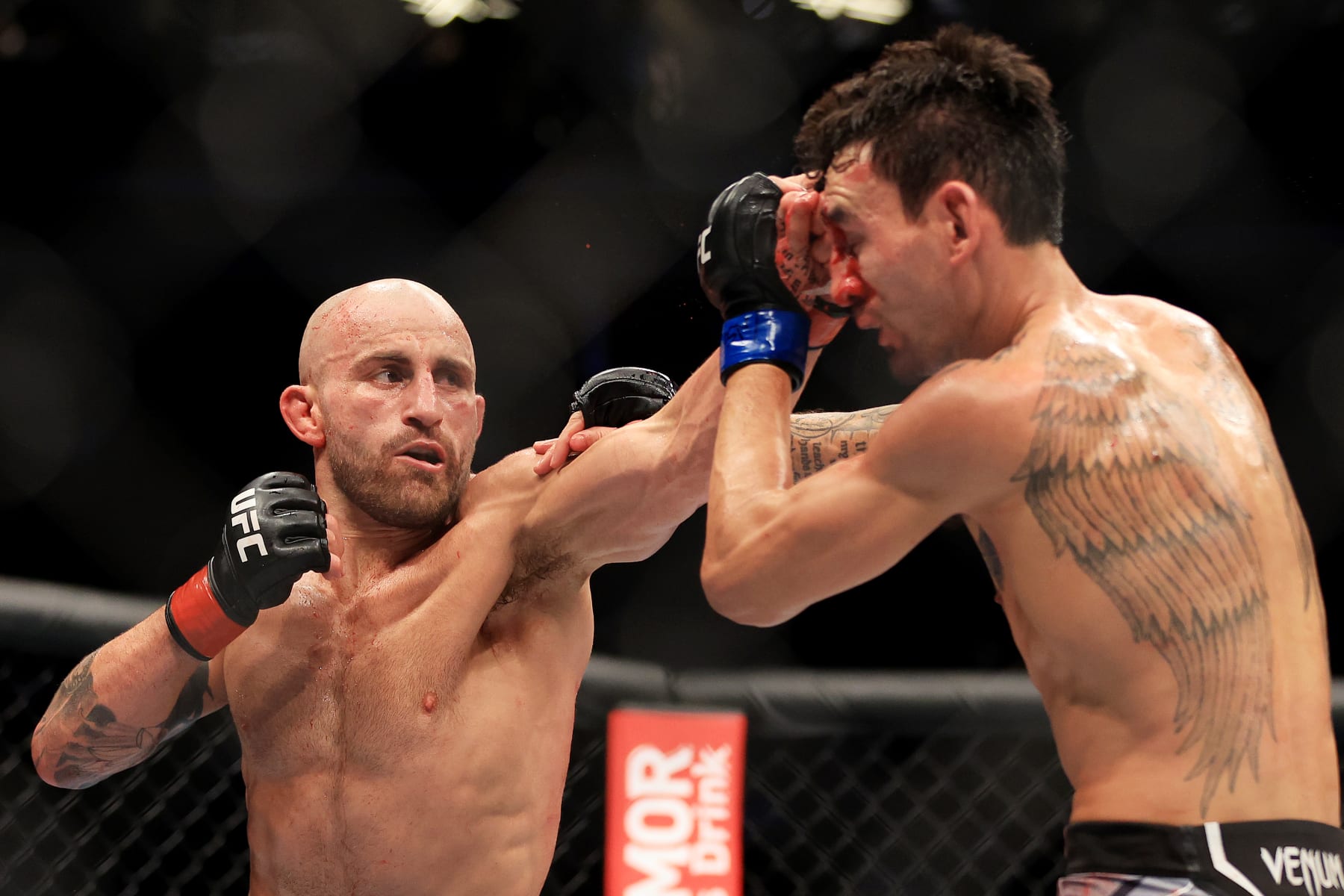 LAS VEGAS, NEVADA - JULY 02: Alexander Volkanovski (L) of Australia punches Max Holloway in their featherweight title bout during UFC 276 at T-Mobile Arena on July 02, 2022 in Las Vegas, Nevada. (Photo by Carmen Mandato/Getty Images)