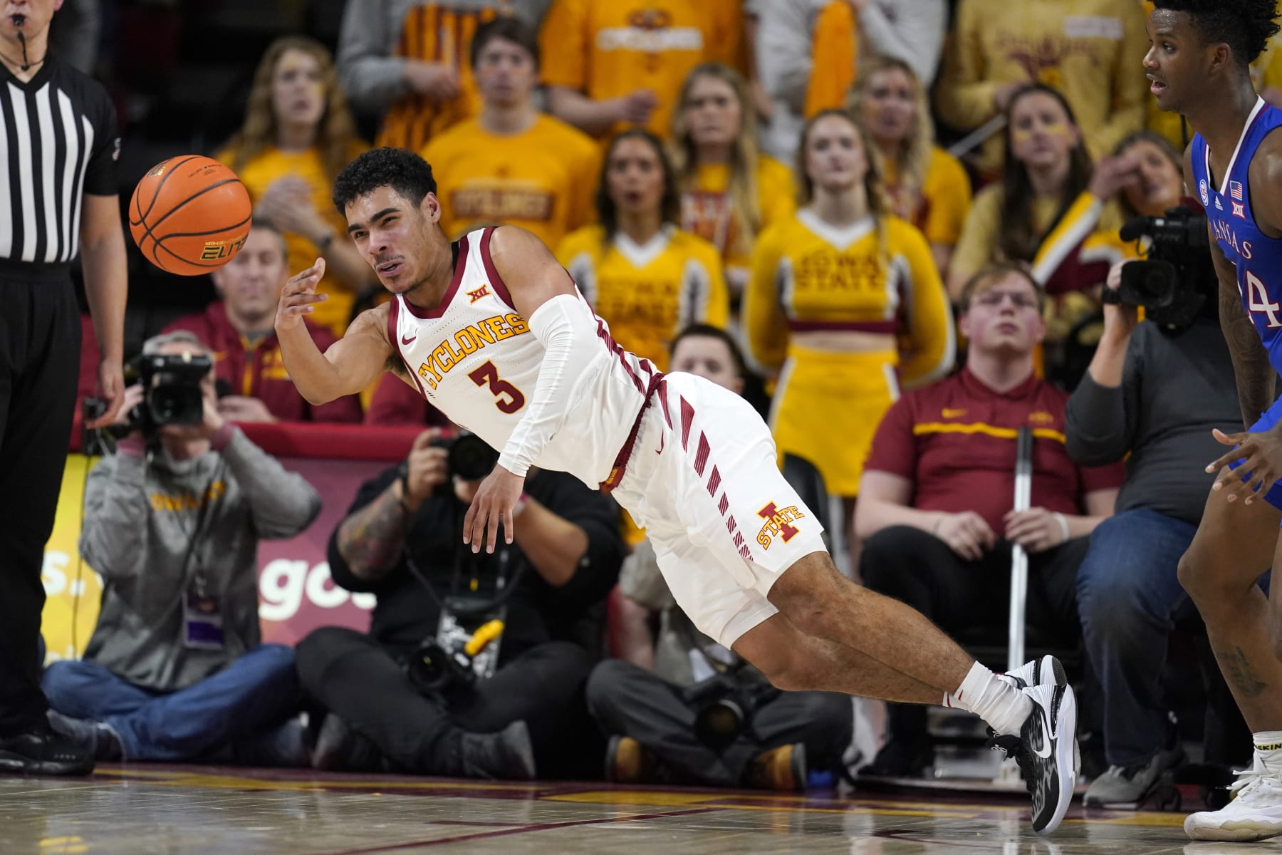 Iowa State guard Tamin Lipsey (3) passes to a teammate in front of Kansas forward K.J. Adams Jr., right, during the second half of an NCAA college basketball game, Saturday, Feb. 4, 2023, in Ames, Iowa. (AP Photo/Charlie Neibergall)