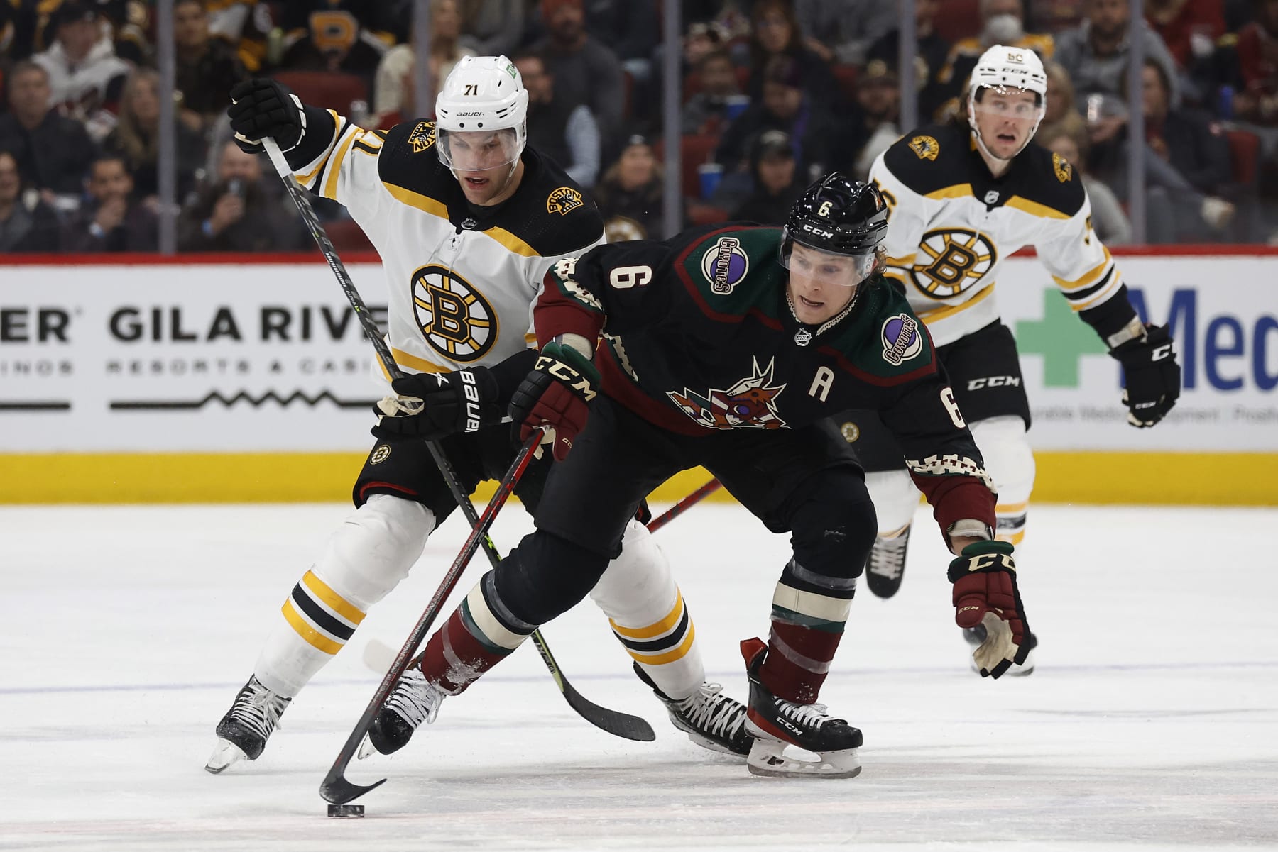 GLENDALE, ARIZONA - JANUARY 28: Jakob Chychrun #6 of the Arizona Coyotes and Taylor Hall #71 of the Boston Bruins fight for control of the puck in the second period of the game at Gila River Arena on January 28, 2022 in Glendale, Arizona. (Photo by Christian Petersen/Getty Images)
