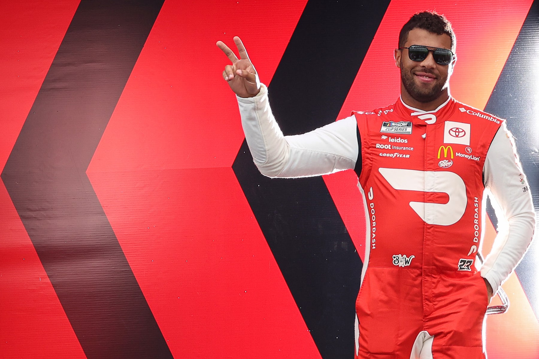DAYTONA BEACH, FLORIDA - AUGUST 28: Bubba Wallace, driver of the #23 DoorDash Toyota, waves to fans as he walks onstage during driver intros prior to the NASCAR Cup Series Coke Zero Sugar 400 at Daytona International Speedway on August 28, 2022 in Daytona Beach, Florida. (Photo by James Gilbert/Getty Images)