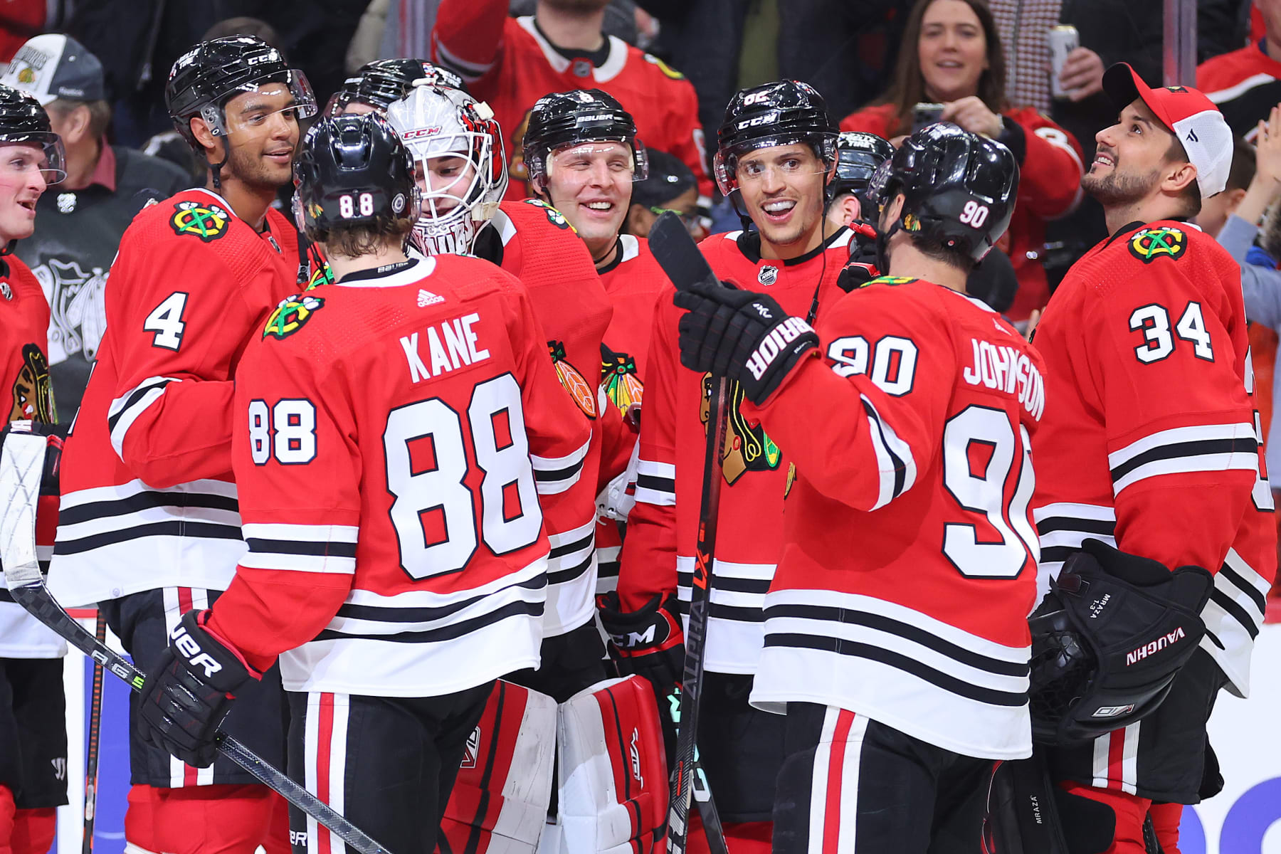 CHICAGO, ILLINOIS - FEBRUARY 10: Caleb Jones #82 of the Chicago Blackhawks celebrates teammates after scoring a game-winning goal in overtime against the Arizona Coyotes at United Center on February 10, 2023 in Chicago, Illinois. (Photo by Michael Reaves/Getty Images)