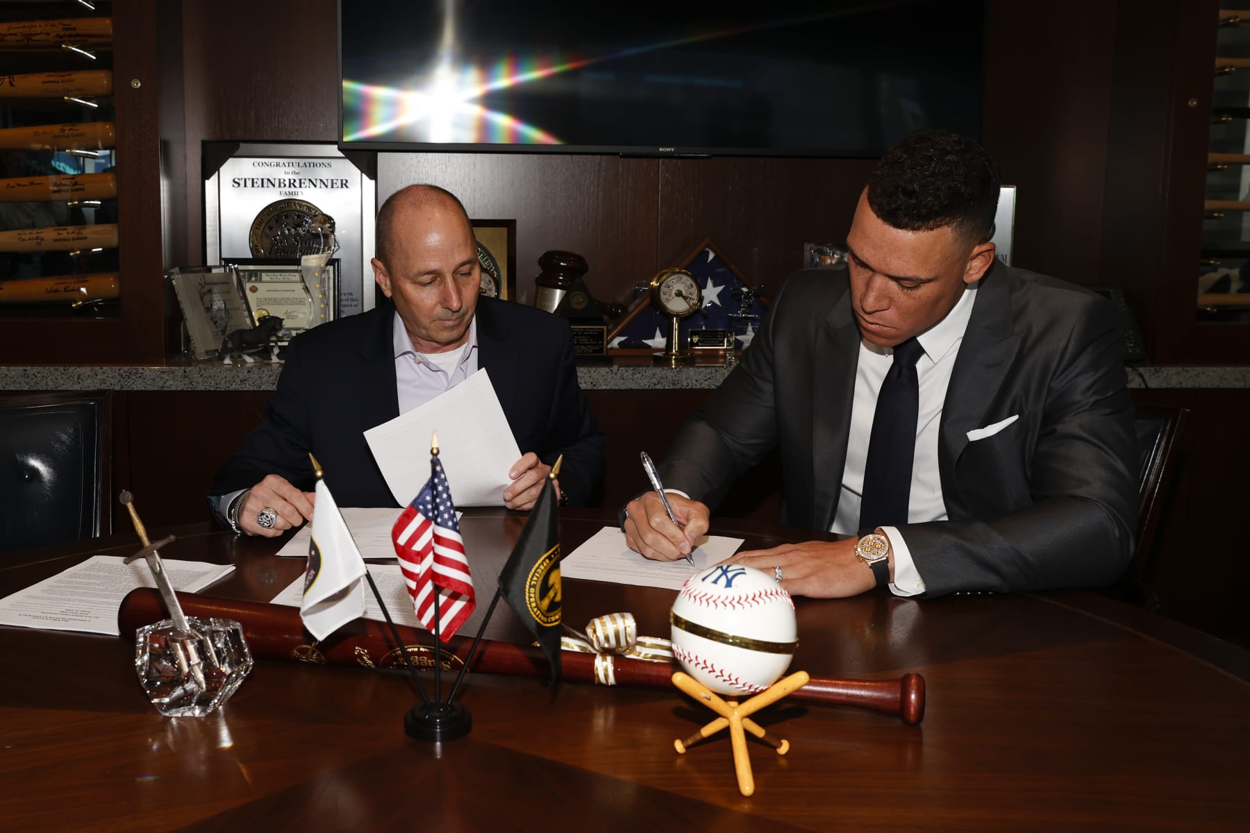 NEW YORK, NY - DECEMBER 21: General manager Brian Cashman of the New York Yankees and Aaron Judge #99 finalize Judges nine-year contract before a press conference at Yankee Stadium on December 21, 2022 in the Bronx, New York. (Photo by New York Yankees/Getty Images)