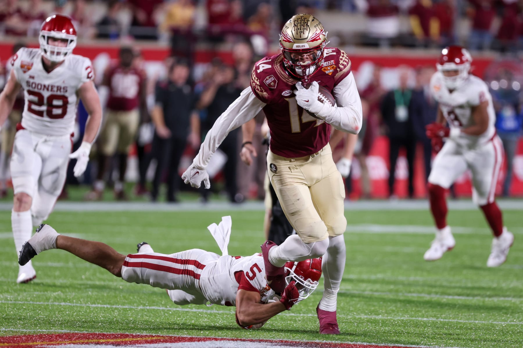 ORLANDO, FL - DECEMBER 29: Florida State Seminoles wide receiver Johnny Wilson (14) escapes a tackle from Oklahoma Sooners defensive back Billy Bowman (5) during the Cheez-It Bowl between Oklahoma and Florida State on December 29, 2022 at Camping World Stadium, in Orlando FL. (Photo by Joe Petro/Icon Sportswire via Getty Images)