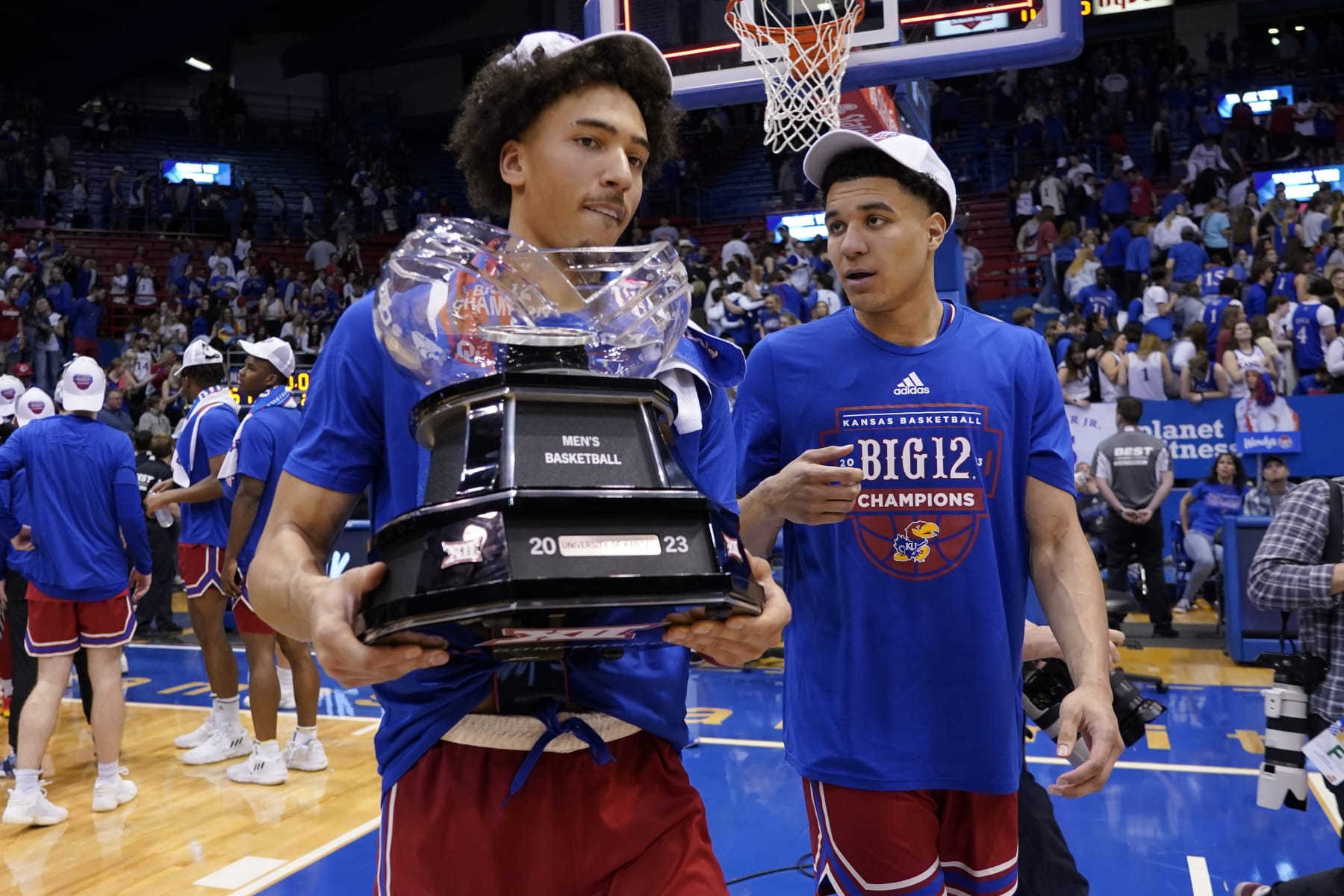 LAWRENCE, KANSAS - FEBRUARY 28: Jalen Wilson (L) #10 carries the Big 12 conference trophy with teammate Kevin McCullar Jr. #15 of the Kansas Jayhawks after their 67-63 win over Texas Tech Red Raiders at Allen Fieldhouse on February 28, 2023 in Lawrence, Kansas. (Photo by Ed Zurga/Getty Images)