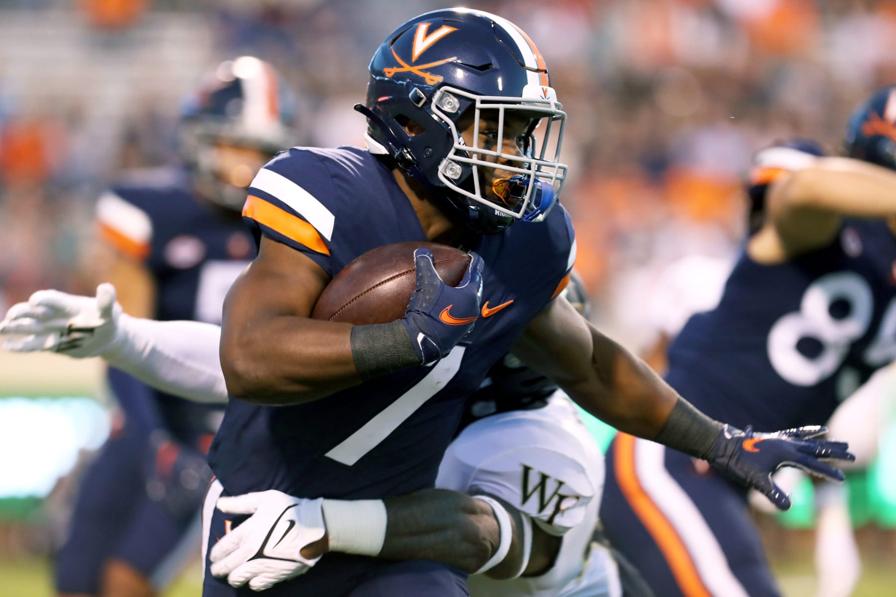 CHARLOTTESVILLE, VA - SEPTEMBER 24: Mike Hollins #7 of the Virginia Cavaliers returns a kickoff in the first half during against the Wake Forest Demon Deacons a game at Scott Stadium on September 24, 2021 in Charlottesville, Virginia. (Photo by Ryan M. Kelly/Getty Images)