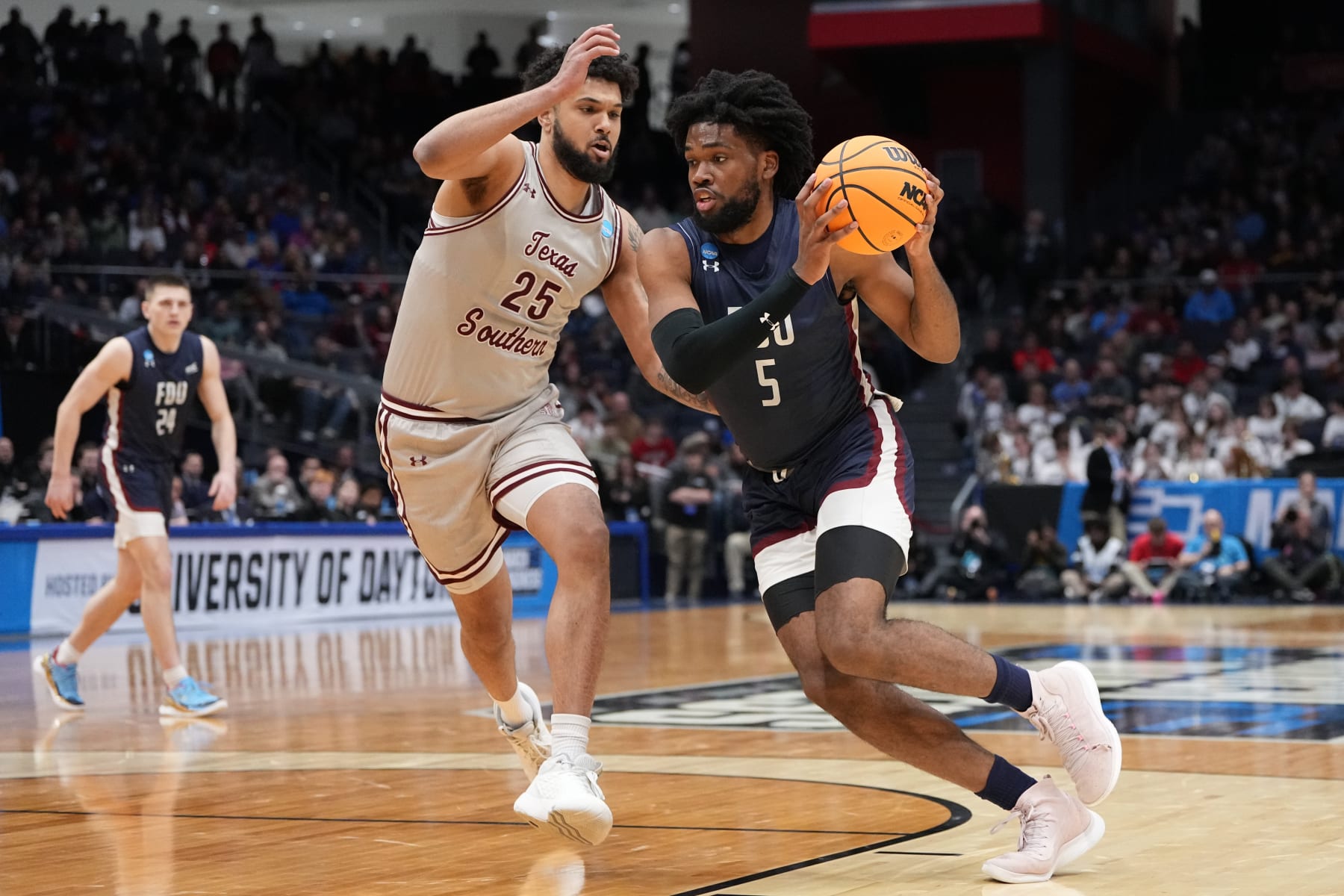 DAYTON, OHIO - MARCH 15: Ansley Almonor #5 of the Fairleigh Dickinson Knights drives to the basket against Grayson Carter #25 of the Texas Southern Tigers during the first half in the First Four game of the NCAA Men's Basketball Tournament at University of Dayton Arena on March 15, 2023 in Dayton, Ohio. (Photo by Dylan Buell/Getty Images)