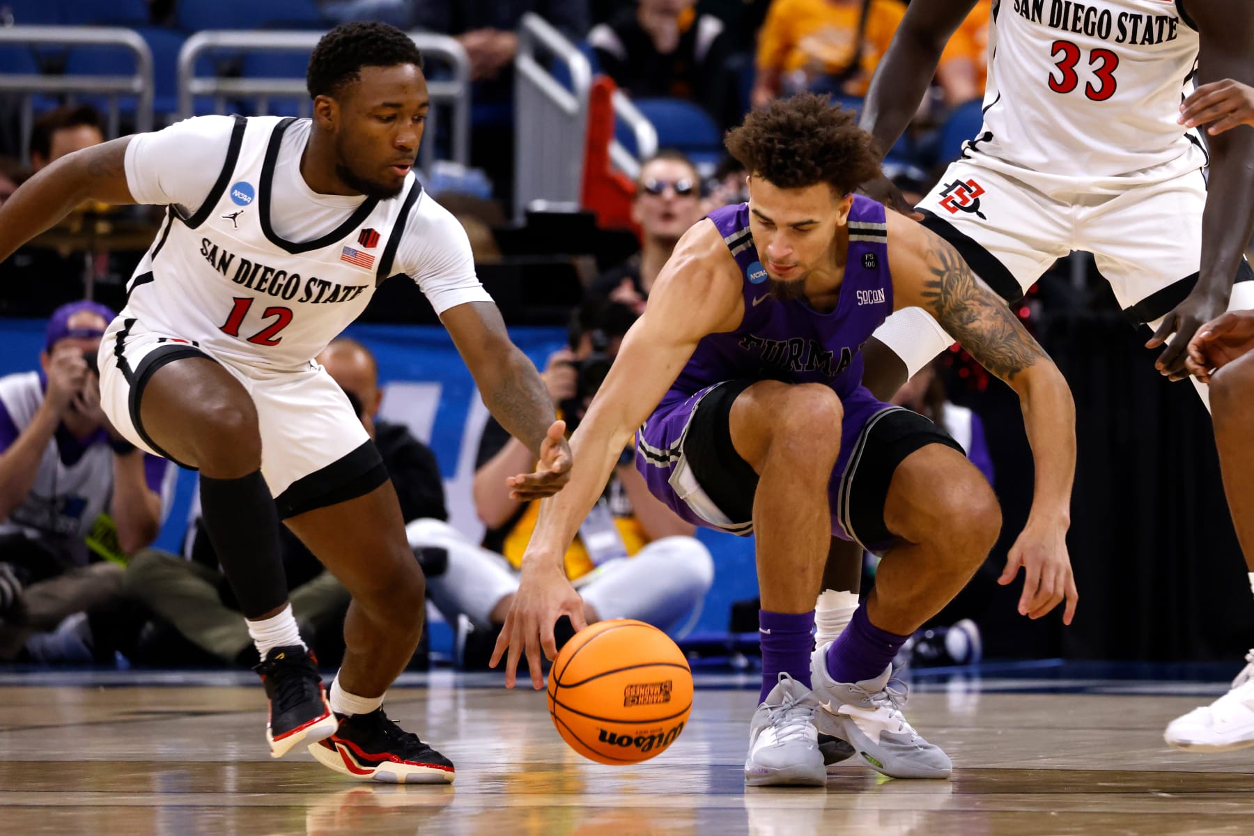 ORLANDO, FL - MARCH 18: Jalen Slawson #20 of the Furman Paladins reaches for the ball against Darrion Trammell #12 of the San Diego State Aztecs during the first half in the second round of the NCAA Men's Basketball Tournament at Amway Center on March 18, 2023 in Orlando, Florida. (Photo by Lance King/Getty Images)