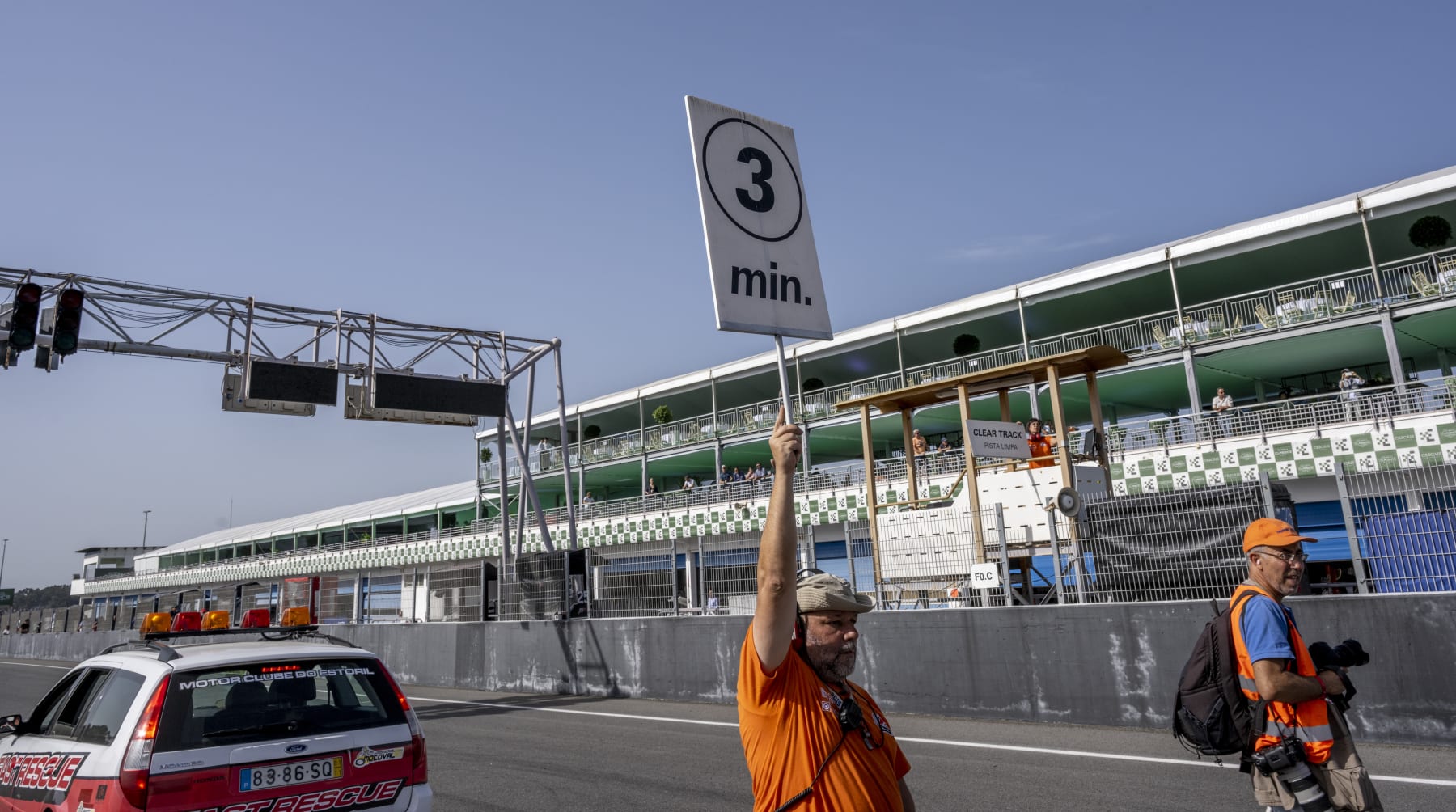 ESTORIL, PORTUGAL - OCTOBER 08: A circuit assistant hoists a sign indicating 3 minutes for the start of a classic endurance race on the 2nd day of Estoril Classics in Fernanda Pires da Silva Estoril Circuit on October 08, 2022 in Estoril, Portugal. More than 300 racing cars are present at the Estoril Circuit during the weekend, for Estoril Classics is back after the interruption due to the COVID-19 pandemic. Among the racers there are 16 Formula 1 cars, that competed from 1971 to 1986. Lotus 78, Ligier JS11, Williams FW07 and Lotus 91, including the Lotus 78 and the Williams FW07 driven by Mario Andretti (1978) and Alan Jones (1980) to be crowned F-1 champions and their teams winners of the Constructors' World Championship. In addition to Formula 1, cars races include GT's, prototypes, and other classics. Estoril Classics was created in 2017 with the goal of bringing to the Estoril Circuit the world's most important classic cars and competitions,  quickly becoming a mandatory event for classic car lovers. The sixth edition of Estoril Classics takes place between October 07 and 09 and brings together four disciplines of classic car racing on the same stage: Formula 1, Sports Cars, GTs and Touring Cars. (Photo by Horacio Villalobos#Corbis/Corbis via Getty Images)