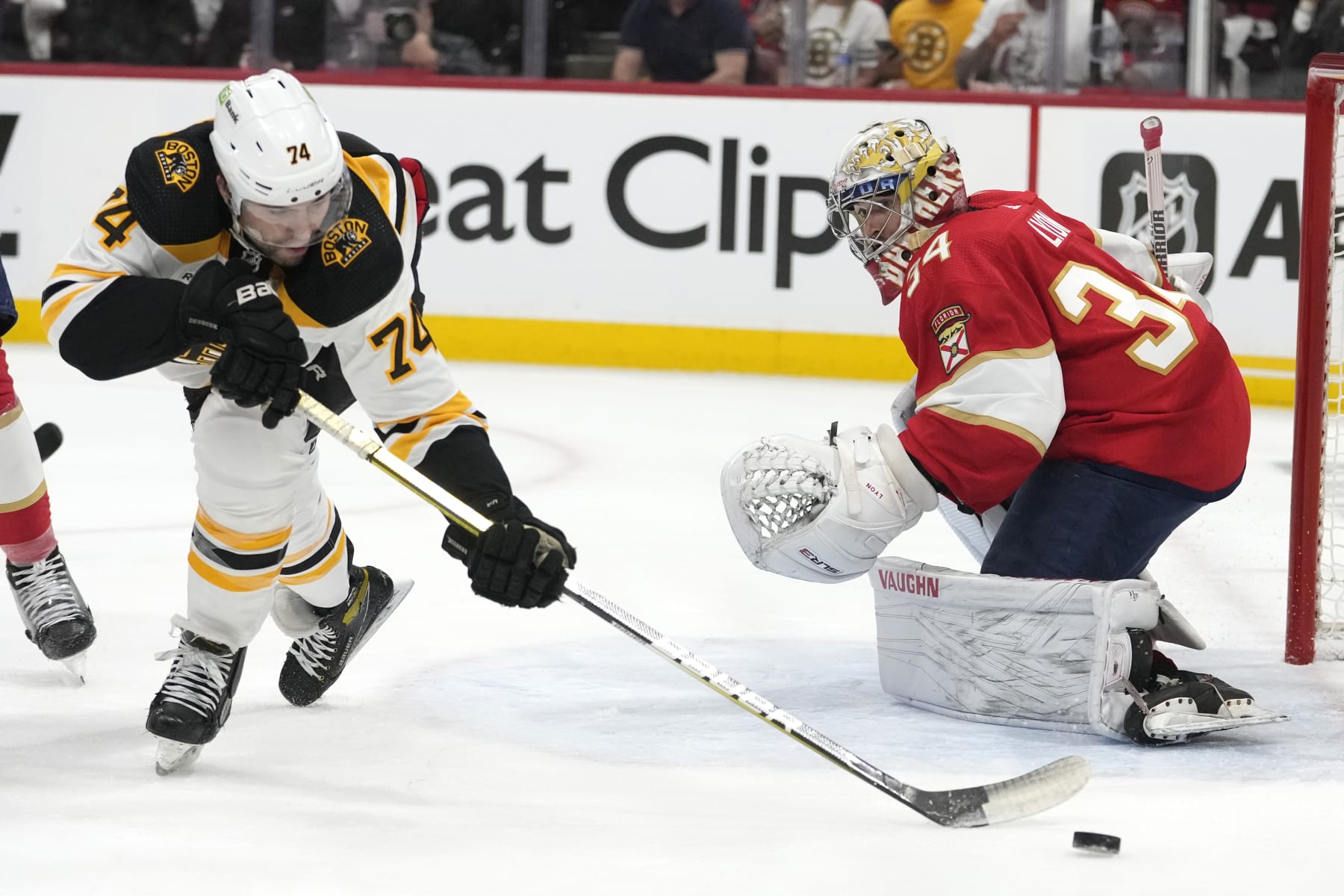 Boston Bruins left wing Jake DeBrusk (74) passes the puck as Florida Panthers goaltender Alex Lyon (34) defends during the first period of Game 3 of an NHL hockey Stanley Cup first-round playoff series, Friday, April 21, 2023, in Sunrise, Fla. (AP Photo/Lynne Sladky)