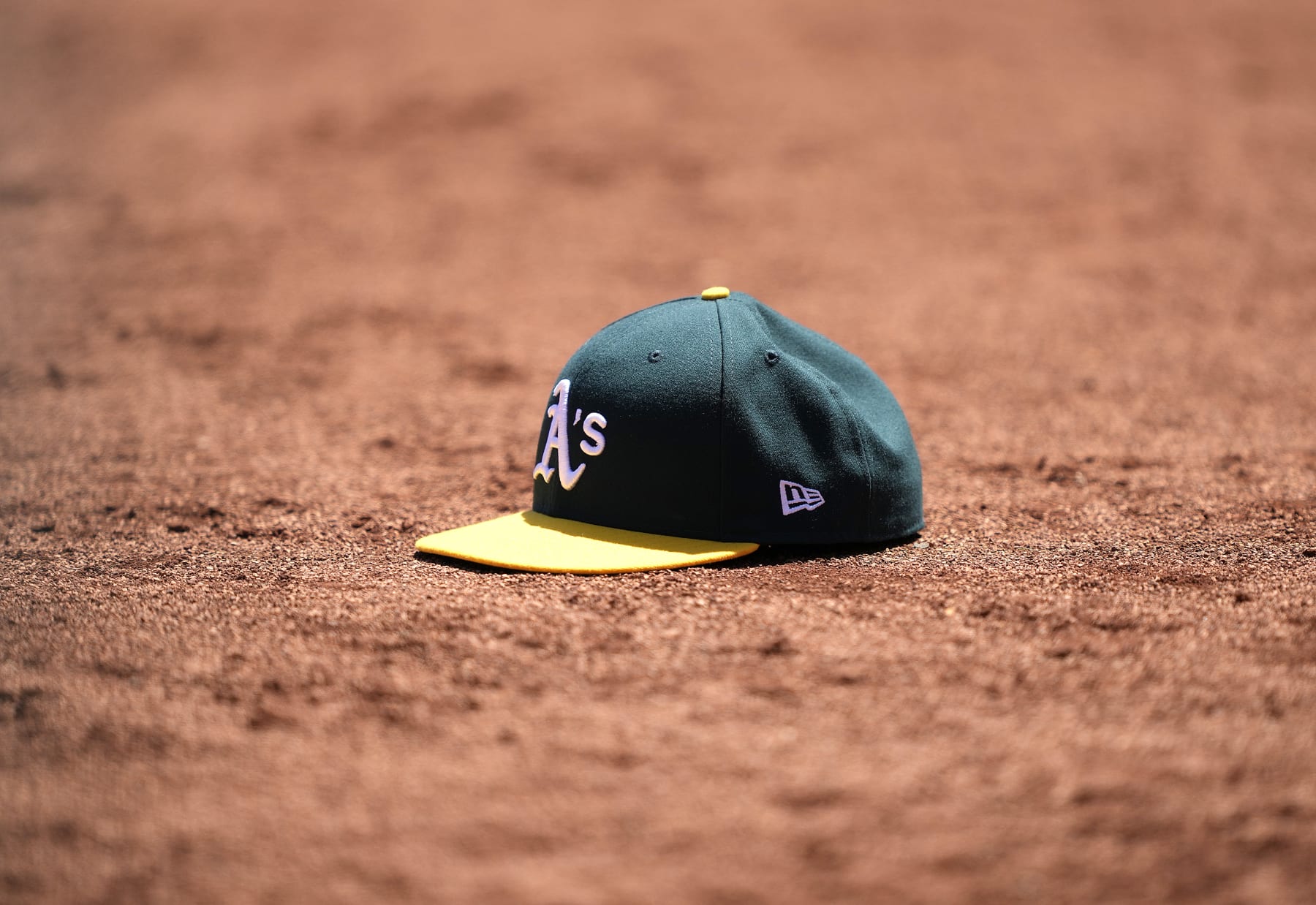 OAKLAND, CALIFORNIA - MAY 17: A detailed view of a cap belonging to a Oakland Athletics player is seen sitting in the dirt of the warning track during a game against the Arizona Diamondbacks at RingCentral Coliseum on May 17, 2023 in Oakland, California. (Photo by Thearon W. Henderson/Getty Images)