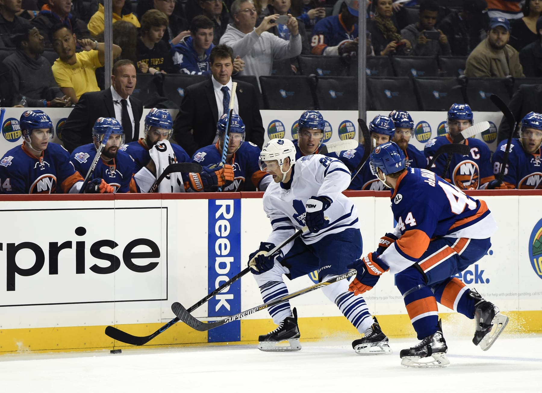 New York Islanders assistant coach Greg Cronin, left and head coach Jack Capuano watch Toronto Maple Leafs right wing Brad Boyes (28) control the puck against Islanders defenseman Calvin de Haan (44) during an NHL hockey game on Sunday, Dec. 27, 2015, in New York. (AP Photo/Kathy Kmonicek)