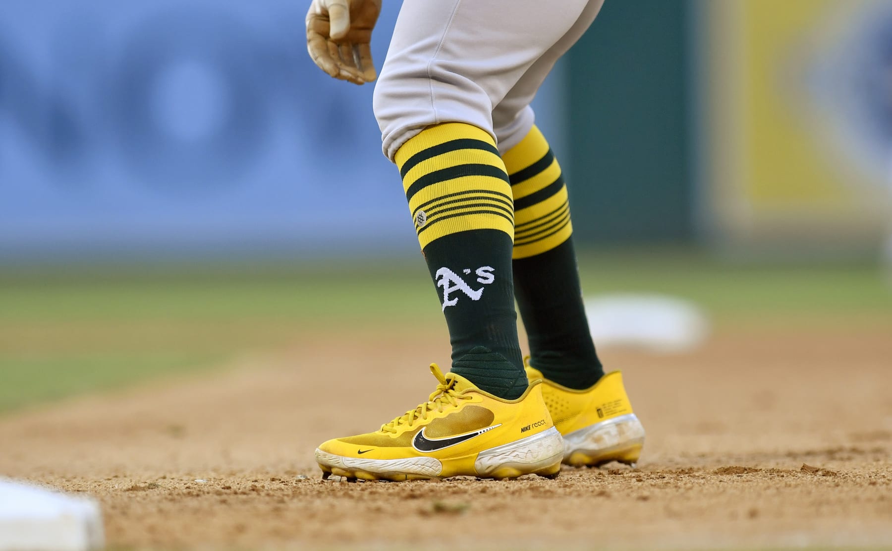 WASHINGTON, DC - SEPTEMBER 01: A close up view of Tony Kemps Oakland As logo baseball socks and yellow Nike React baseball cleats as he take a lead off from first base during the Oakland Athletics As versus Washington Nationals MLB game at Nationals Park on September 1, 2022 in Washington, D.C.. (Photo by Randy Litzinger/Icon Sportswire via Getty Images)