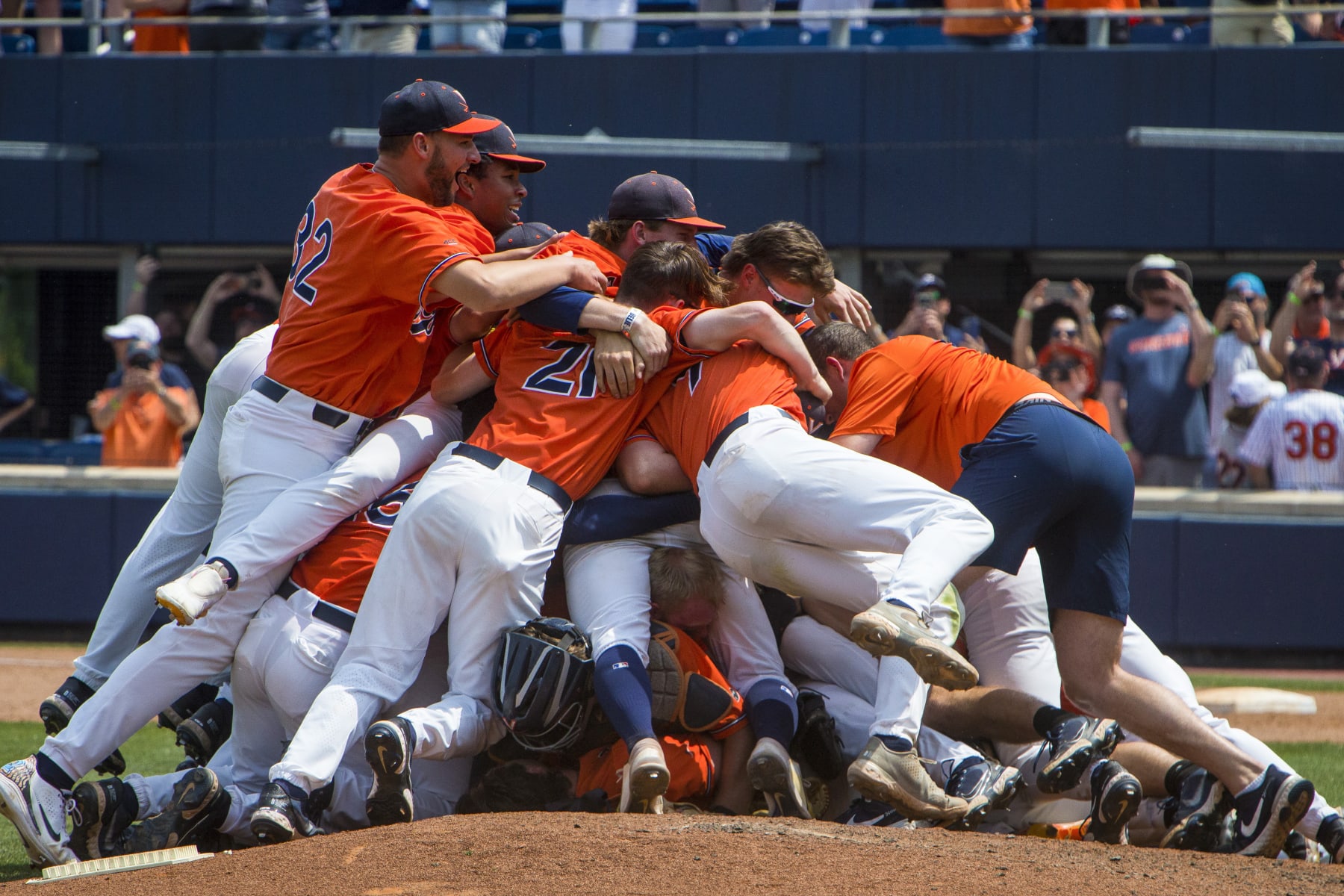 Virginia players dogpile on the pitching mound after winning an NCAA college baseball tournament super regional game against Duke on Sunday, June 11, 2023, in Charlottesville, Va. (AP Photo/John C. Clark)
