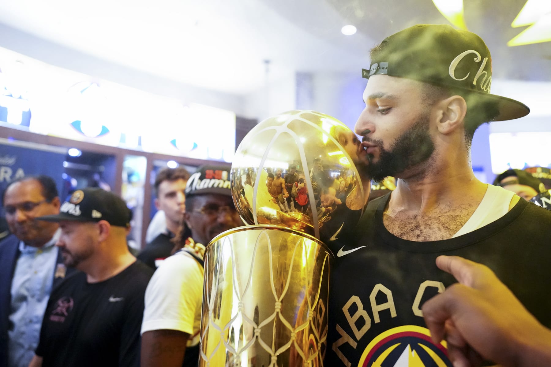 Denver Nuggets' Jamal Murray kisses the Larry O'Brien NBA Championship Trophy inside the locker room after the team won the NBA Championship with a victory over the Miami Heat in Game 5 of basketball's NBA Finals, Tuesday, June 13, 2023, in Denver. (AP Photo/Jack Dempsey)