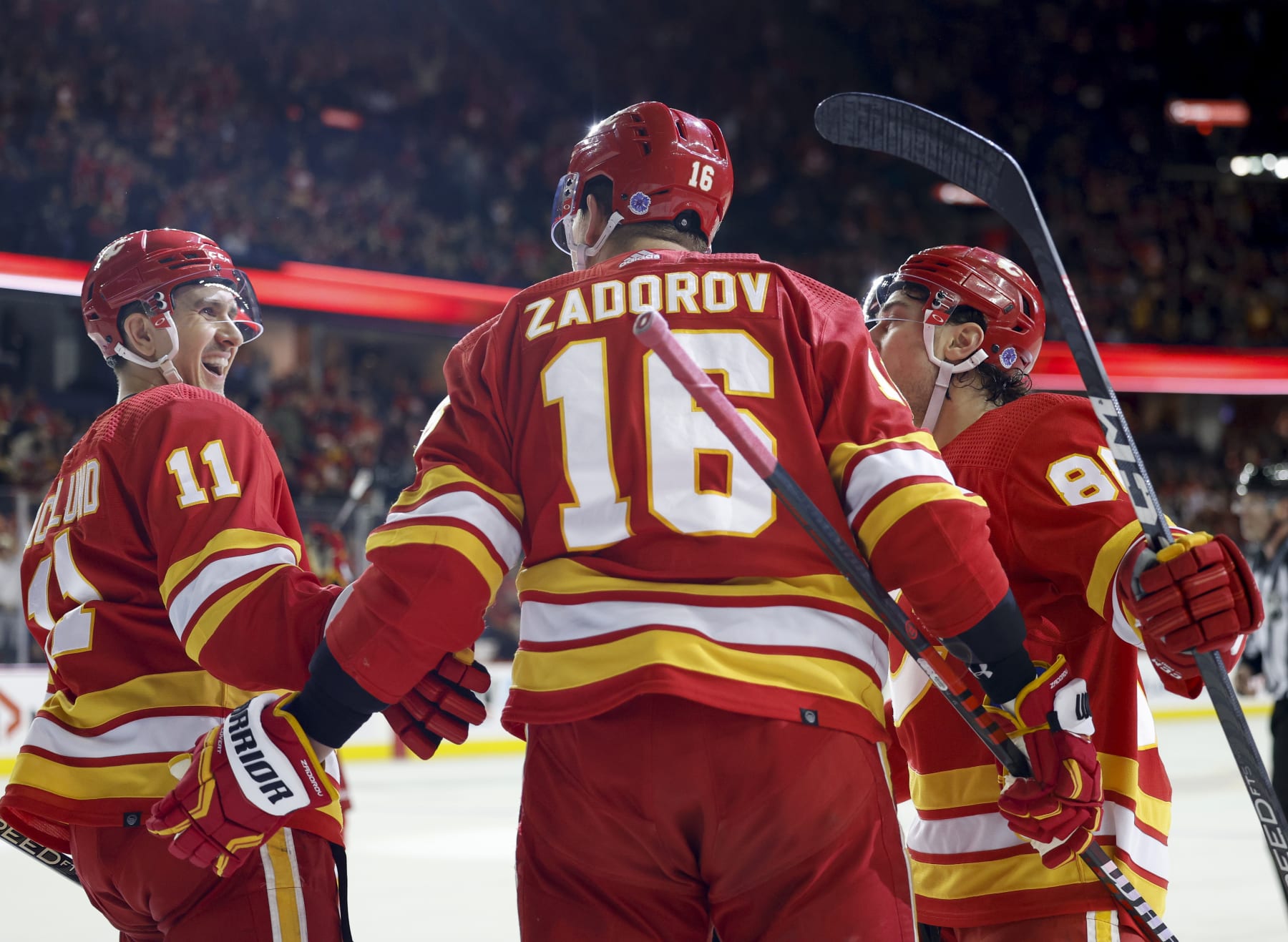 CALGARY, CANADA - APRIL 12: Nikita Zadorov #16 of the Calgary Flames celebrates his second period goal agaisnt the San Jose Sharks with teammates Mikael Backlund #11 of the Calgary Flames and Andrew Mangiapane #88 of the Calgary Flames at the Scotiabank Saddledome on April 12, 2023, in Calgary, Alberta, Canada. (Photo by Leah Hennel/Getty Images)
