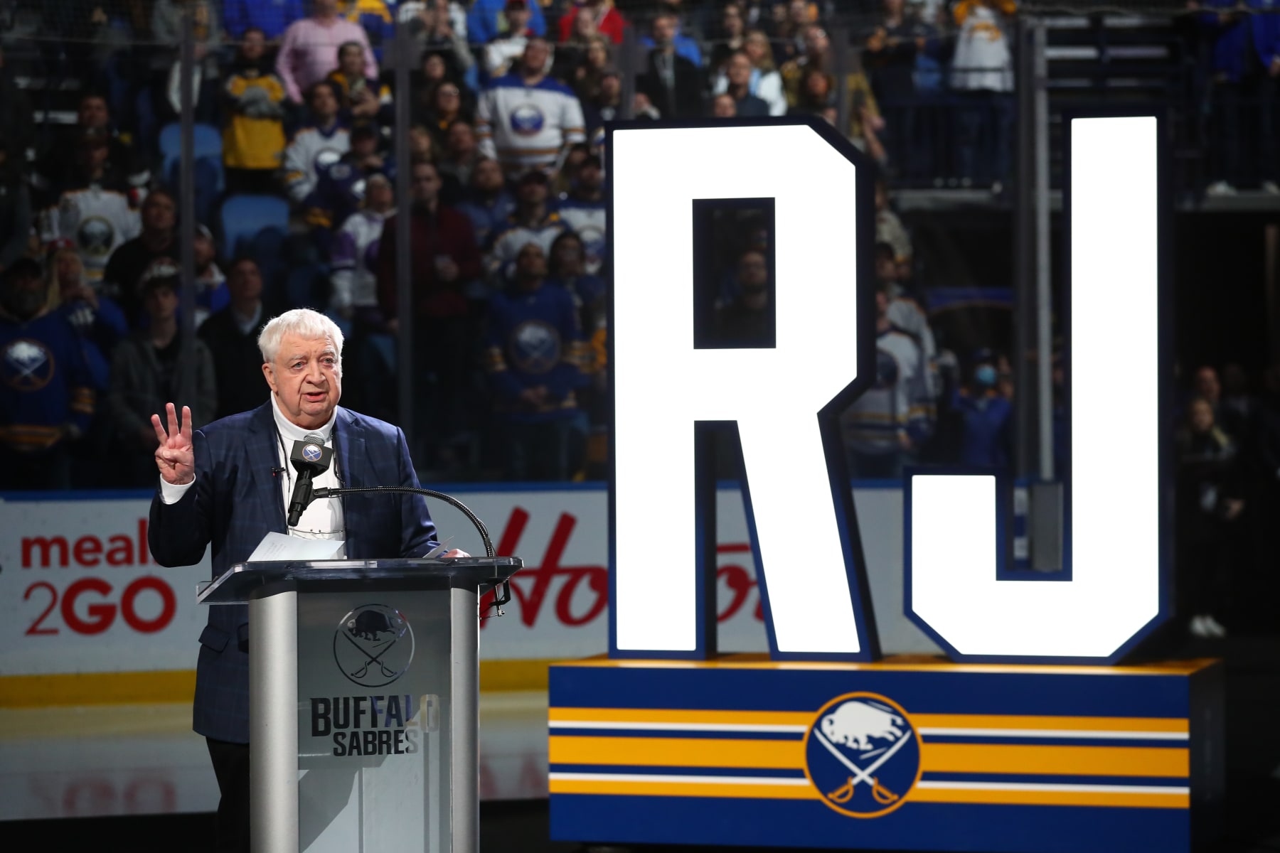 BUFFALO, NY - APRIL 1: Hall-of-Fame Buffalo Sabres play-by-play announcer Rick Jeanneret speaks as a banner bearing his name is added to the rafters of KeyBank Center in a ceremony prior to an NHL game against the Nashville Predators on April 1, 2022 at KeyBank Center in Buffalo, New York. (Photo by Bill Wippert/NHLI via Getty Images)